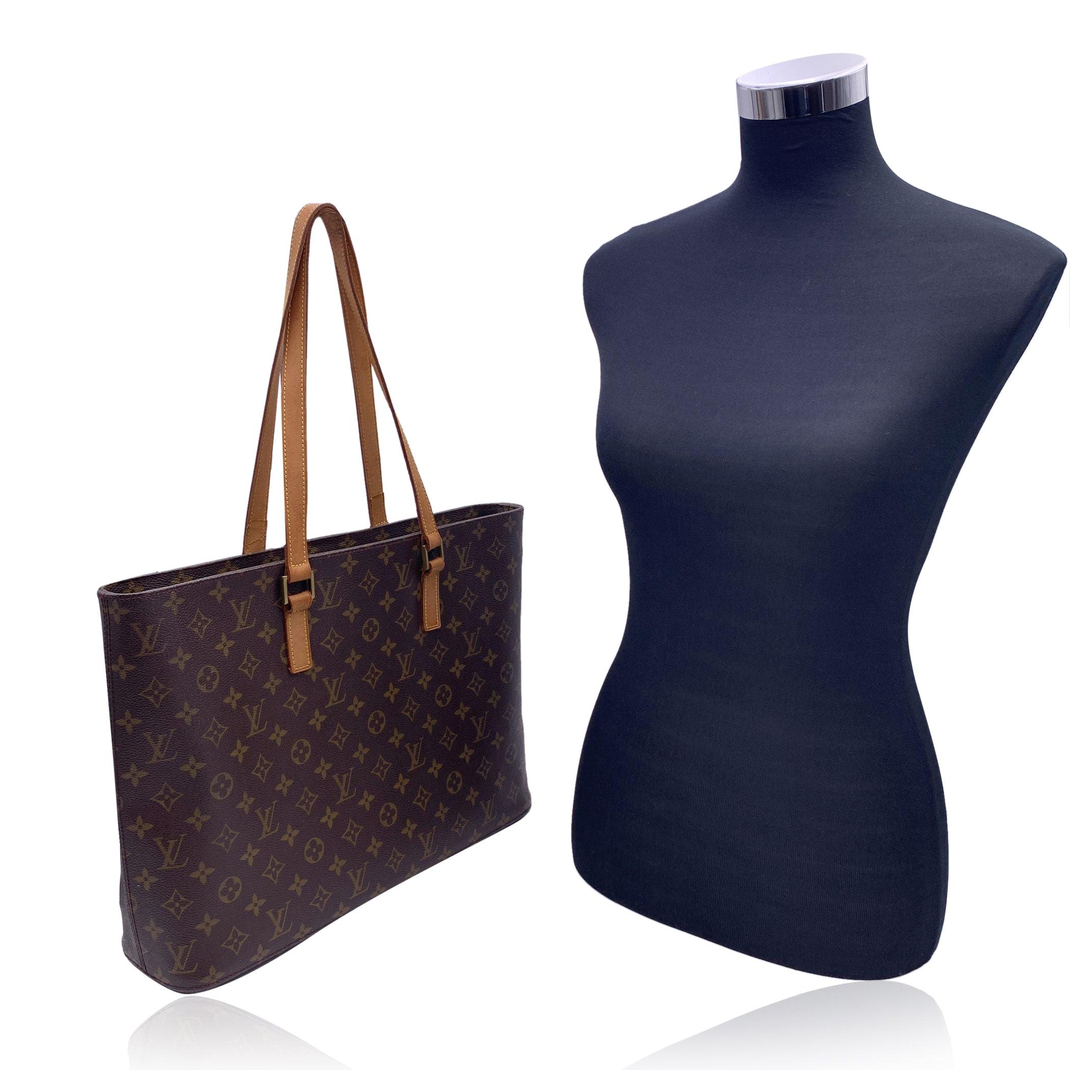 Louis Vuitton Luco Tote Bag in timeless monogram canvas. It features 2 leather shoulder straps. Upper zipper closure. Beige alcantara lining inside with 1 side zipper pocket, 1 side open pocket and 3 smaller open pockets. D-ring inside. 'Louis
