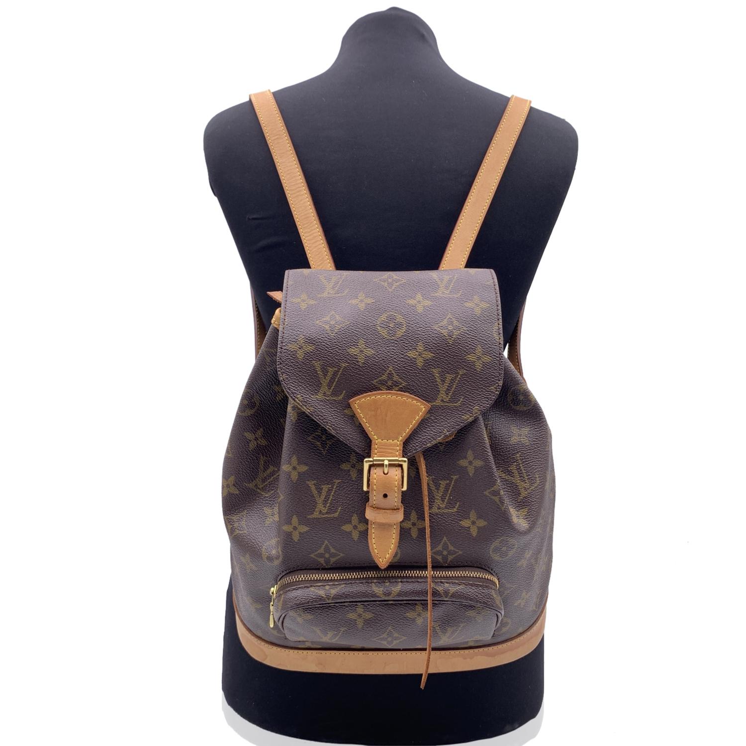 Casual yet sophisticated at the same time Louis Vuitton 'Montsouris MM' Backpack bag. Top is closed with flap with buckle closure and drawstring. 1 front zip pocket. Long and adjustable shoulder straps with gold metal hardware. Brown canvas