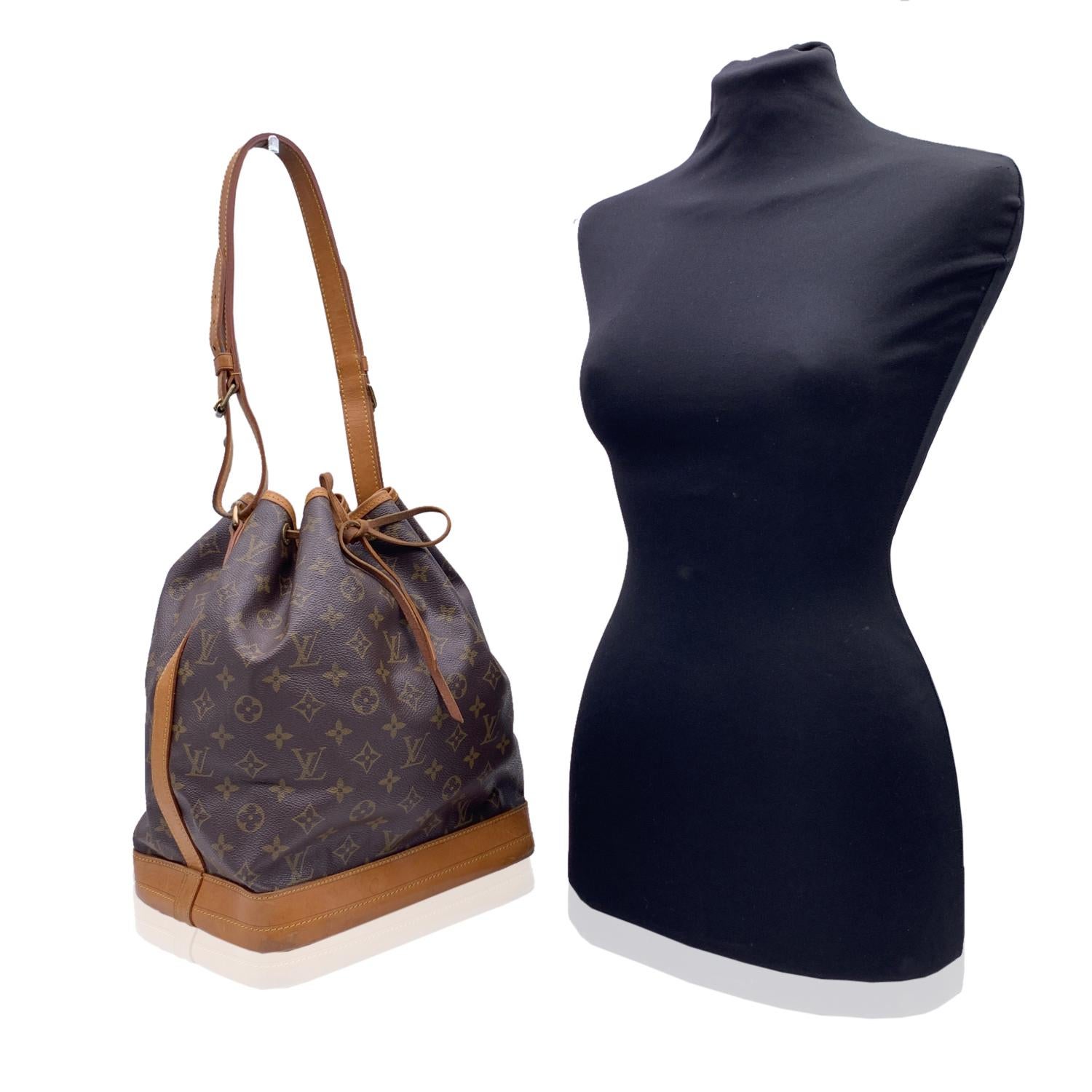 Iconic 'Noé' bucket bag by LOUIS VUITTON was first created in 1932 to carry champagne bottles. Brown monogram canvas with vacchetta leather trim at the bottom, with drawstring closure and microfiber lining. 1 D-Ring inside, Adjustable shoulder