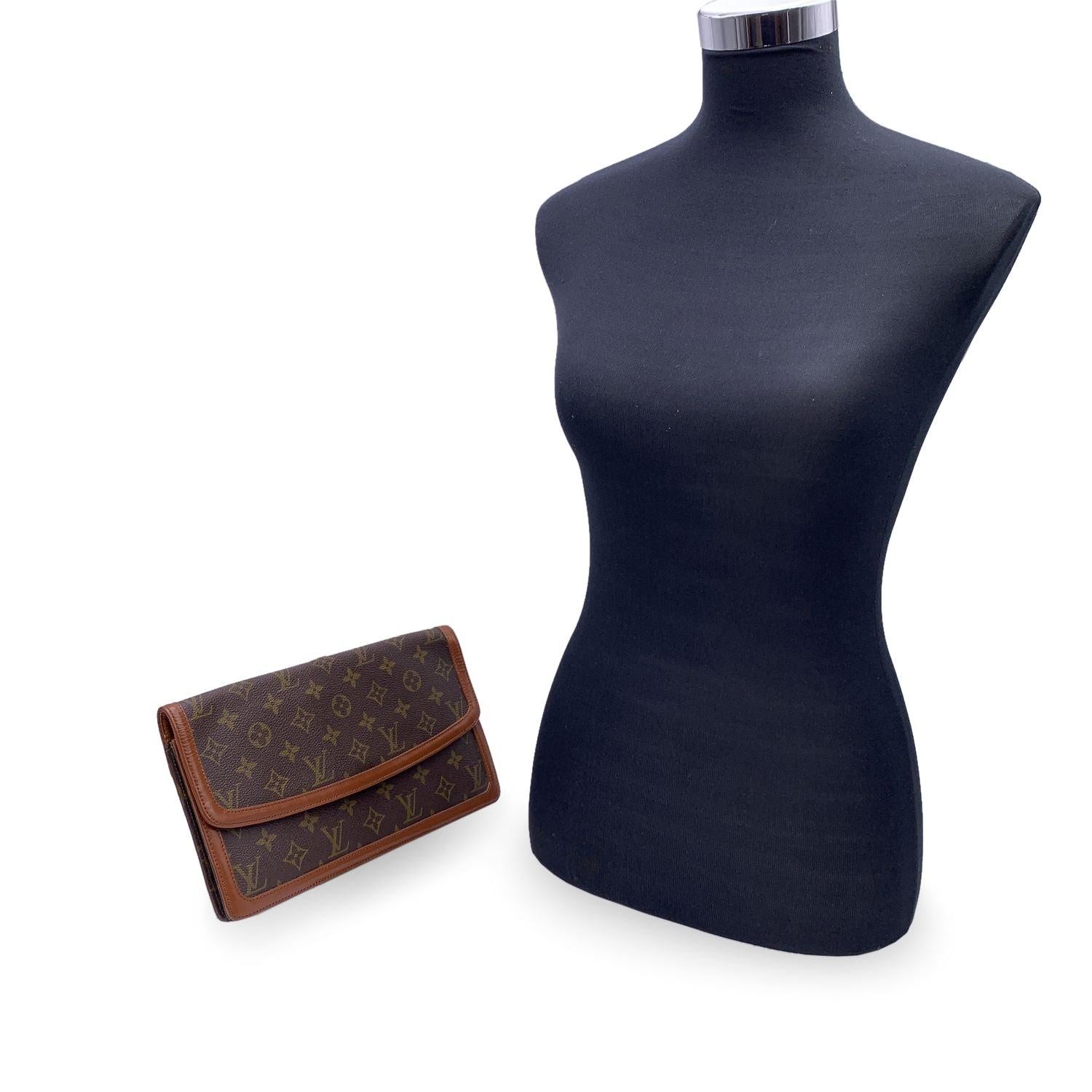 Schöne Louis Vuitton 'Pochette Dame' Clutch Bag aus braunem Monogram Canvas mit braunem Echtlederbesatz. Klappe mit Knopfverschluss auf der Vorderseite. Innenfutter aus Leder. 1 Seitentasche mit Reißverschluss und 2 offene Seitentaschen innen. LOUIS