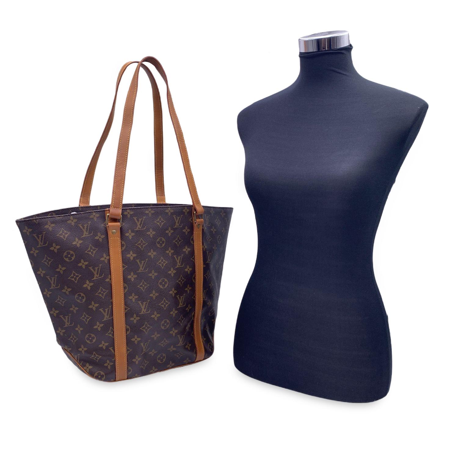 Louis Vuitton Sac Shopping ToteBag. Monogram canvas with leather trim and handles. Open top. Fabric lining with 1 side zip pocket and D-ring inside. Golden color metallic pieces. Beige canvas lining. 'LOUIS VUITTON Paris - Made in France' engraved