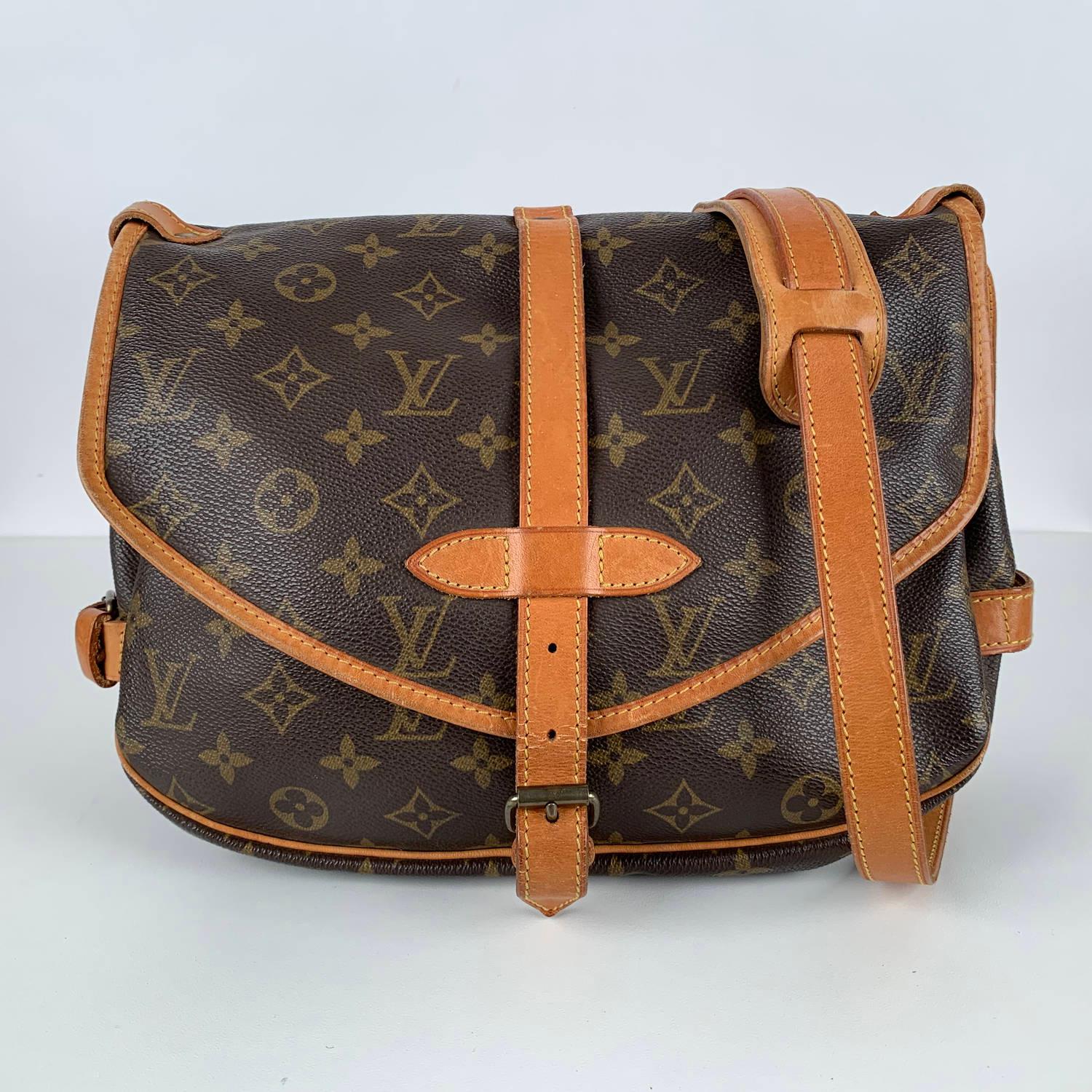 LOUIS VUITTON 'Saumur 30' inspired by equestrian 'SADDLE' bag. The legendary SAUMUR features dual front compartments, held tightly together at the sides with belt-like tabs. Adjustable long shoulder strap with pad for added comfort. 

- Monogram