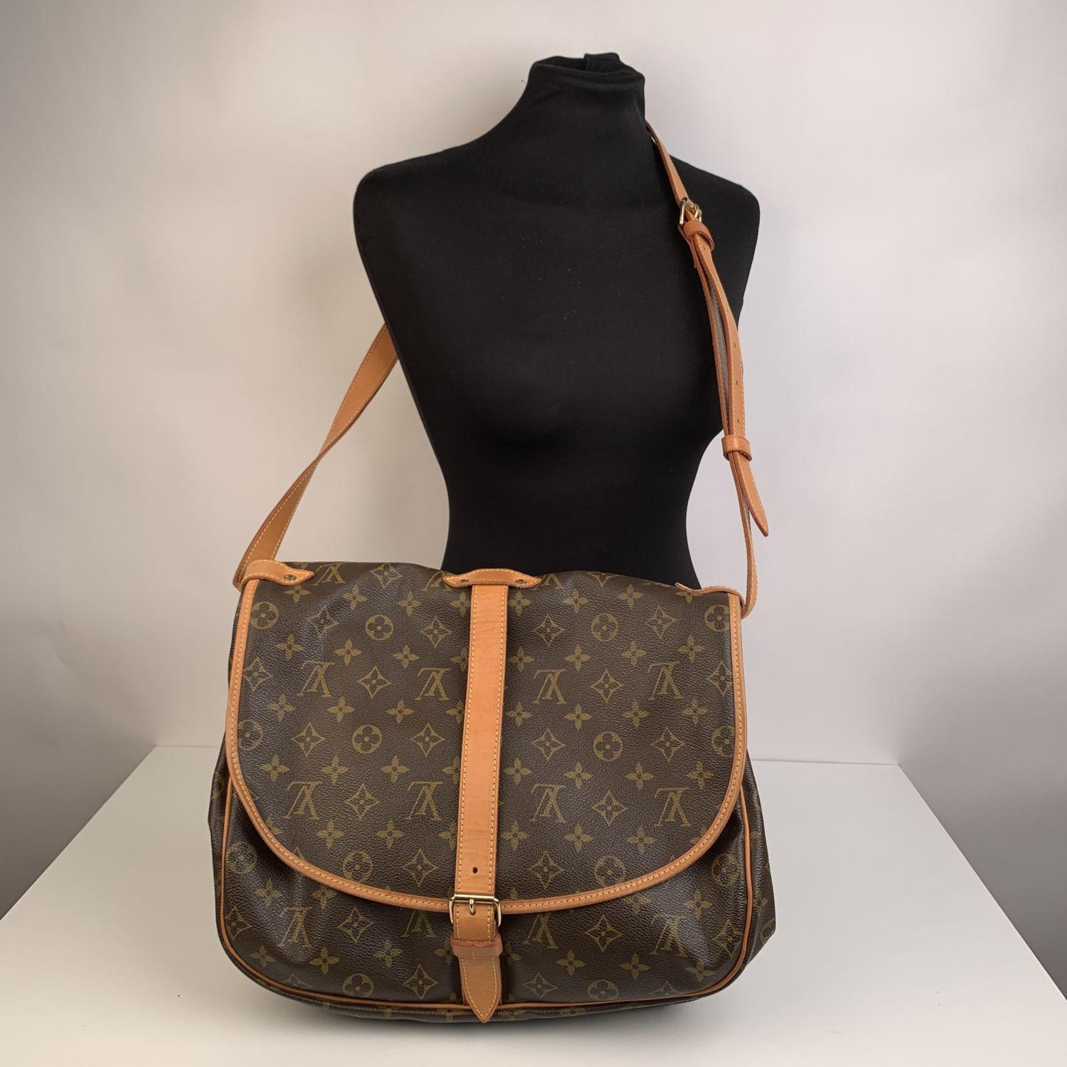 LOUIS VUITTON 'Saumur 35' inspired by equestrian 'SADDLE' bag. The legendary SAUMUR features dual front compartments, held tightly together at the sides with belt-like tabs. Adjustable long shoulder strap with pad for added comfort.

- Monogram