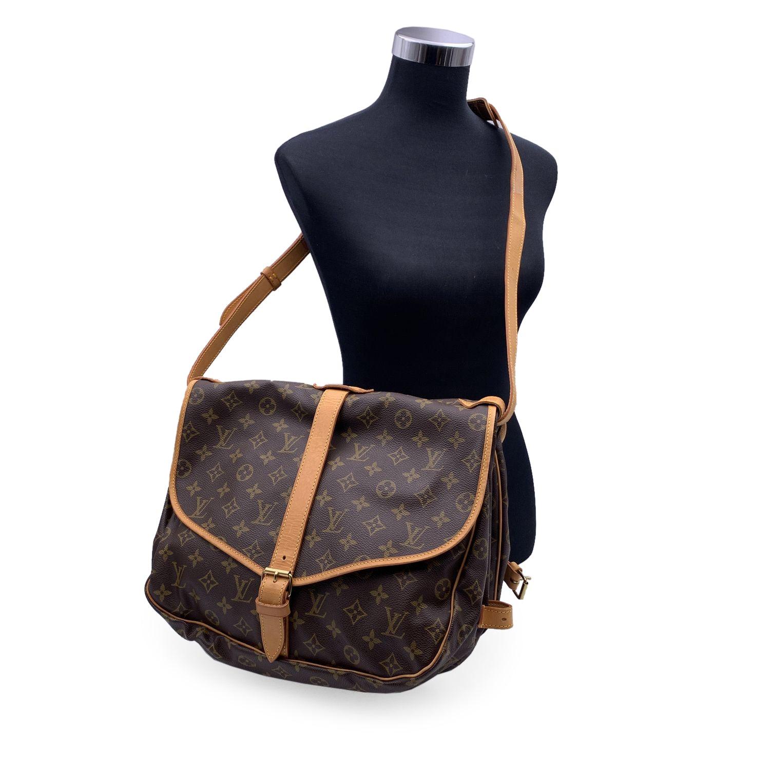 LOUIS VUITTON 'Saumur 35' inspired by equestrian 'SADDLE' bag. The legendary SAUMUR features dual front compartments, held tightly together at the sides with belt-like tabs. Adjustable long shoulder strap with pad for added comfort. 'LOUIS VUITTON