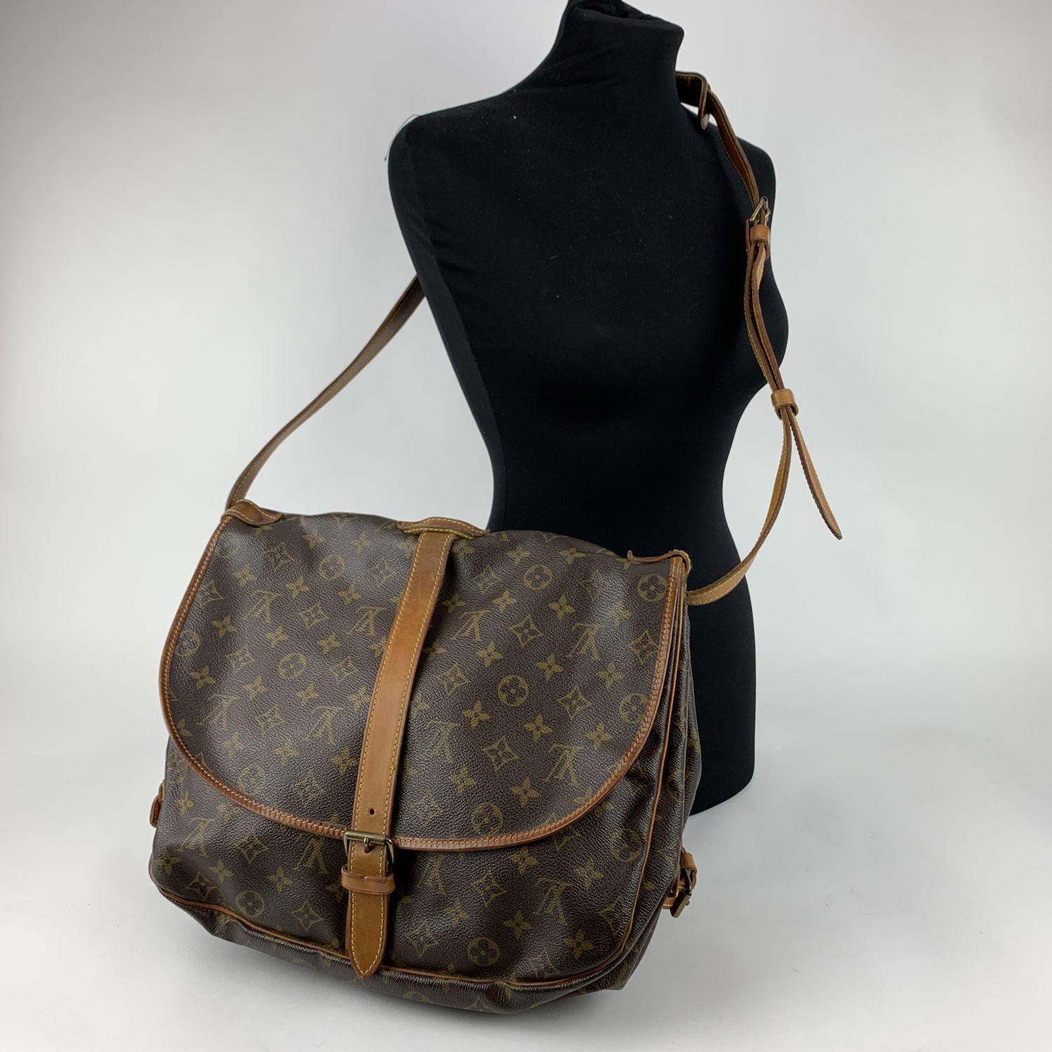 LOUIS VUITTON 'Saumur 35' inspired by equestrian 'SADDLE' bag. The legendary SAUMUR features dual front compartments, held tightly together at the sides with belt-like tabs. Adjustable long shoulder strap with pad for added comfort.

- Monogram