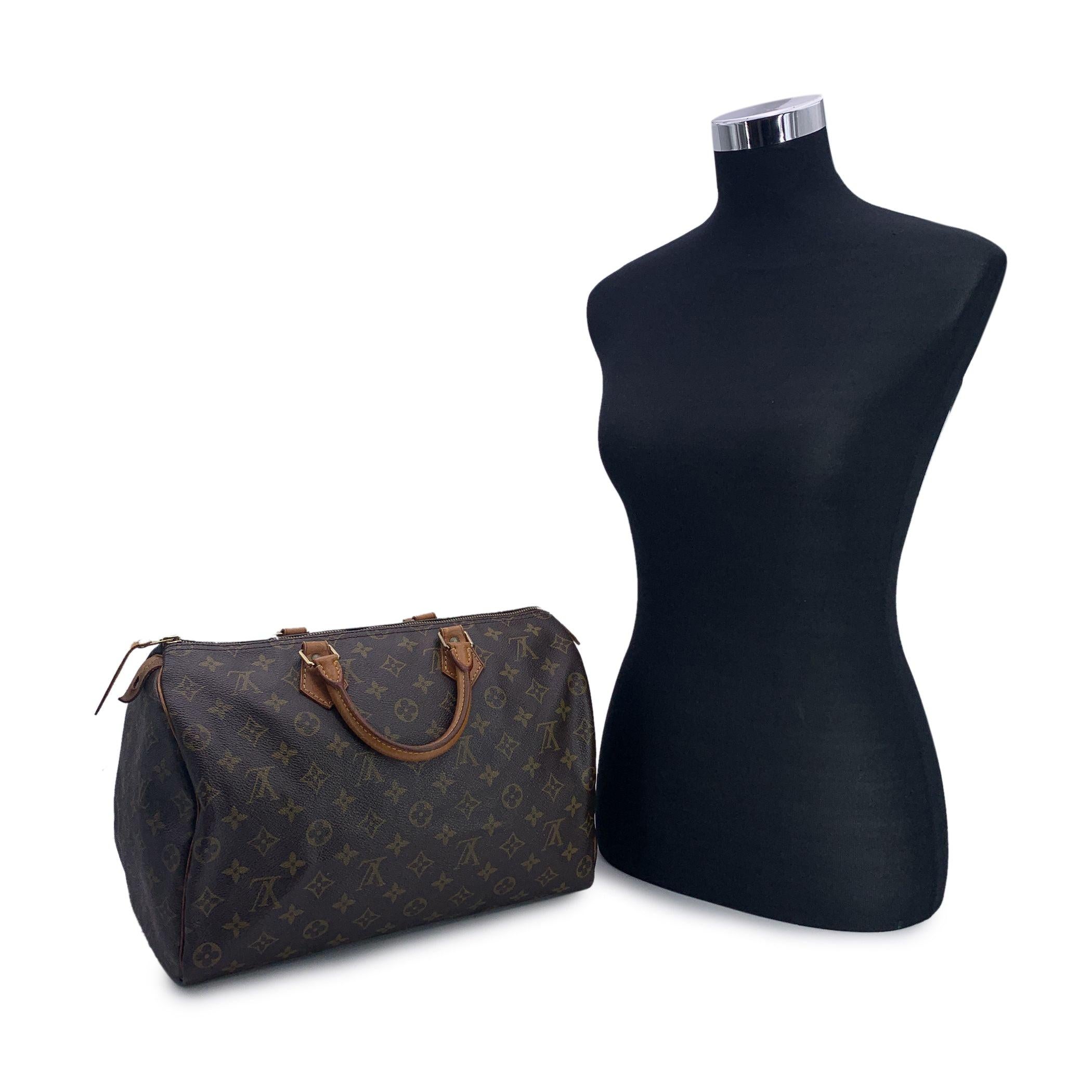 This classic Louis Vuitton SPEEDY 35, one of the most popular lines in the LV monogram. Rounded form, double leather handles and piping. Brown monogram canvas. Gold metal signed hardware. Upper zipper closure with tan leather zipper pull. Brown