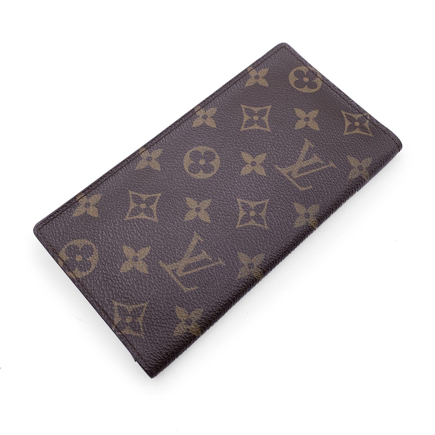 Louis Vuitton Brown Monogram Vertical Wallet. Brown leather inside. 3 side pockets and 6 credit card slots inside. 'LOUIS VUITTON Paris - Made in France' engraved on leather inside. Authenticity serial number embossed inside Details MATERIAL: Cloth