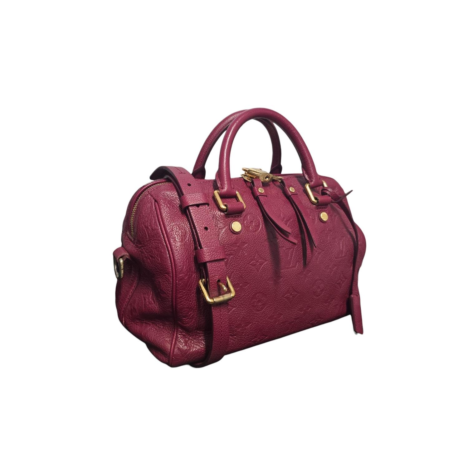 This Louis Vuitton Monogram Empreinte Speedy Bandouliere 25 is expertly crafted from embossed monogram leather in a rich Burgundy hue. Featuring polished brass hardware, rolled leather top handles, and a removable, adjustable strap, it offers