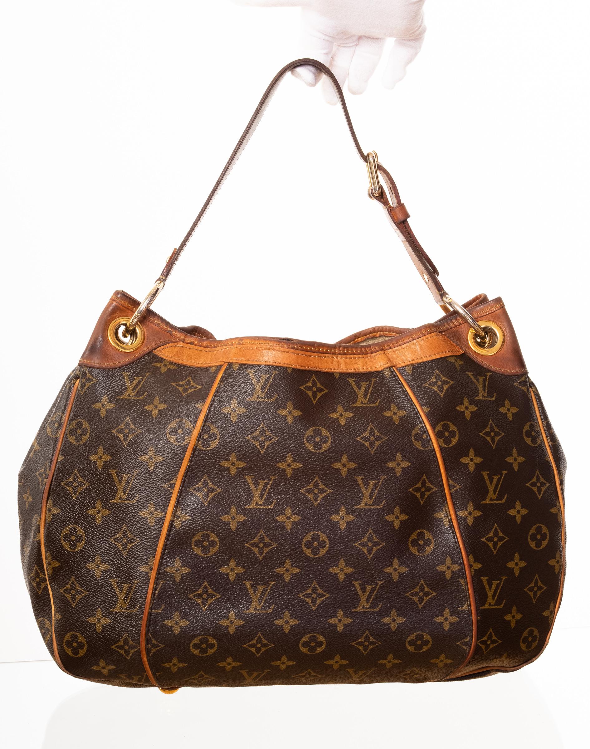 This vintage LV Galleria Bag is made with brown Monogram canvas with vachetta leather finishes and features an etched plate with logo at front, single shoulder strap, brass hardware and protective feet at base. Top snap closure and alcantara