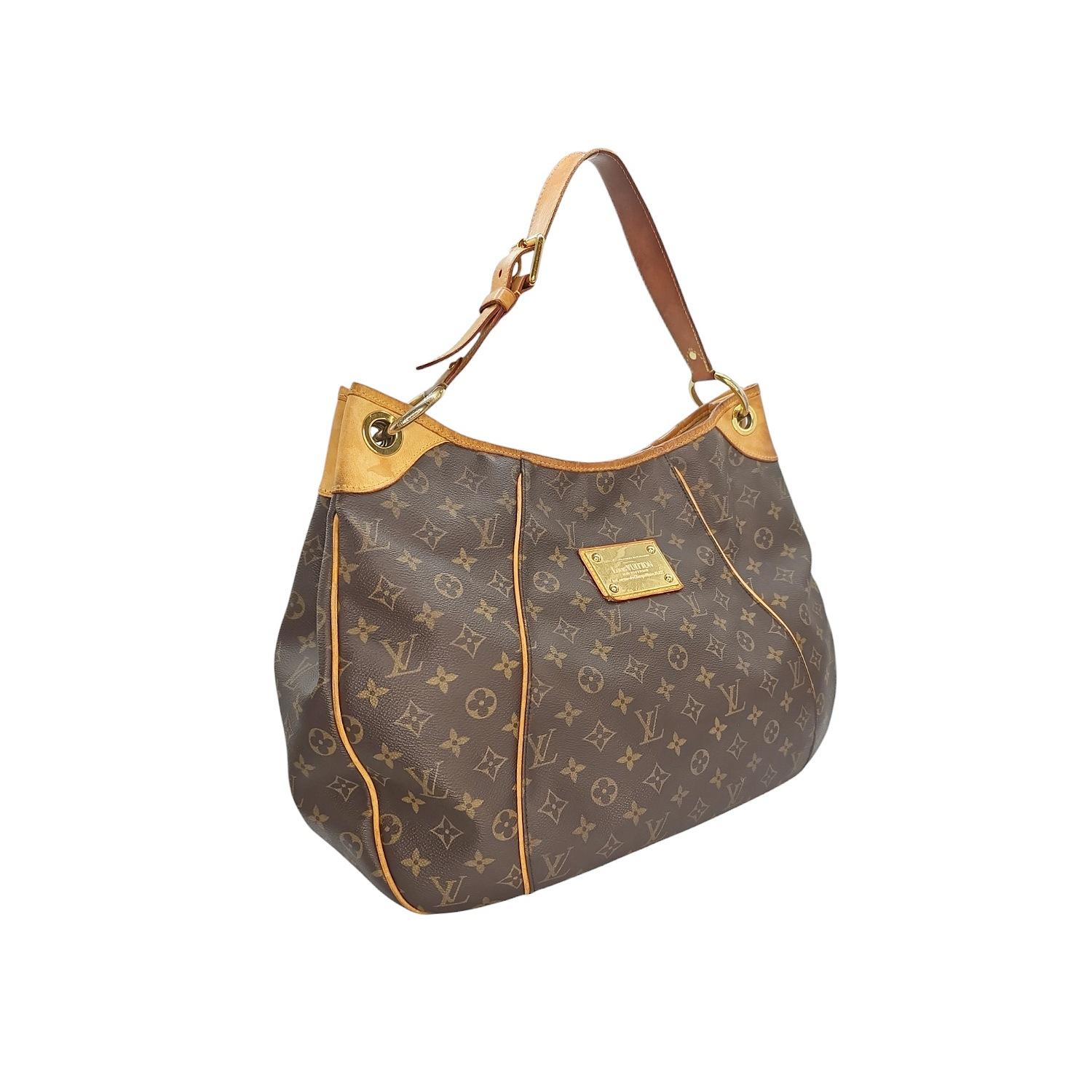 Elevate your style with the exquisite Louis Vuitton Monogram Galleria GM bag. Made in the USA, this premium bag is crafted from the iconic Monogram coated canvas with leather trimming and gold-tone hardware. Featuring a magnetic snap closure, the
