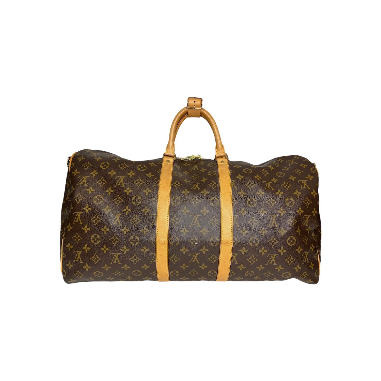 This Louis Vuitton Keepall Bandoulière 55 travel bag was made in 2004 in France and it is finely crafted of the classic brown Louis Vuitton Monogram coated canvas exterior with leather trimmings and gold-tone hardware features. It has rolled leather