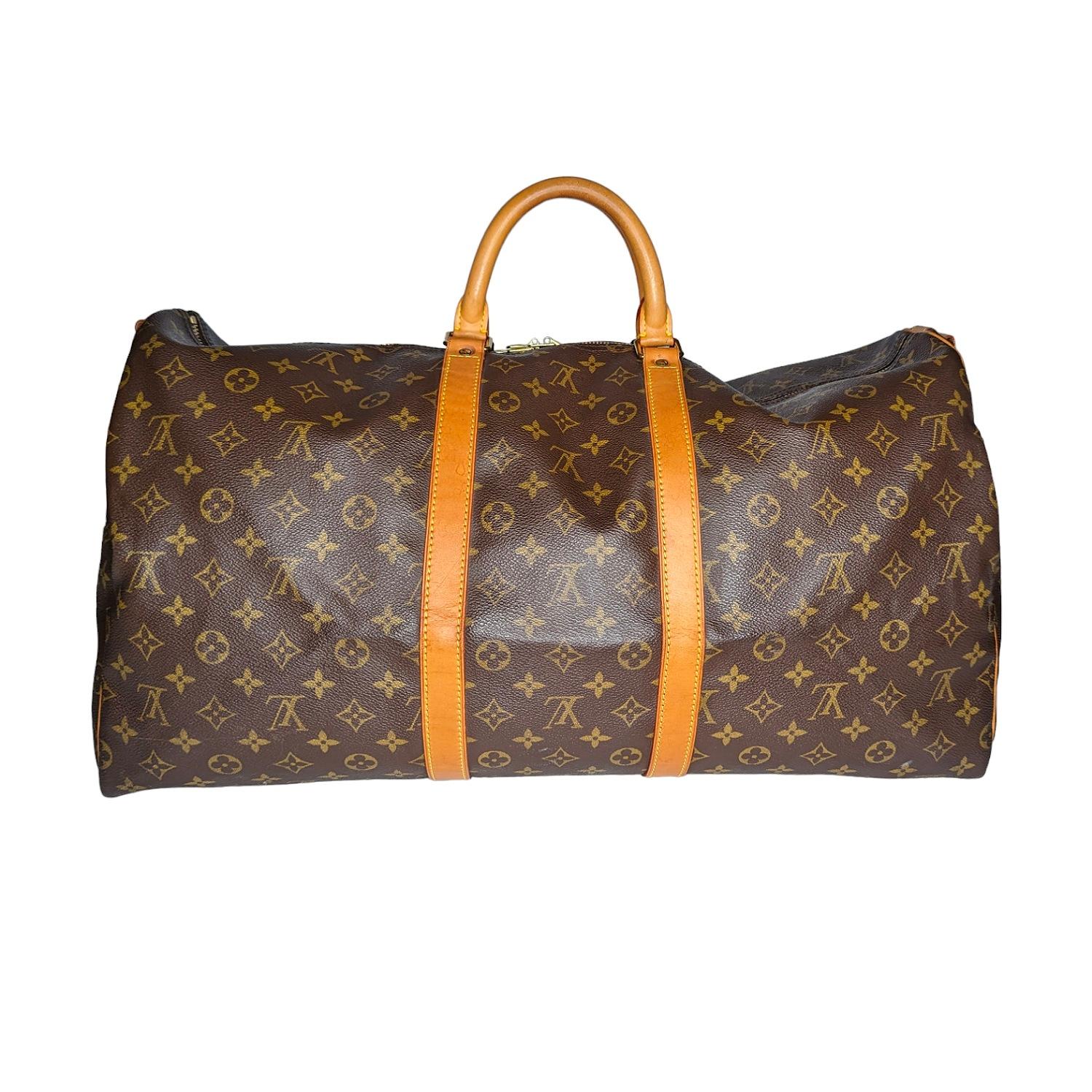 This vintage duffle is crafted of signature Louis Vuitton monogram on dark brown toile coated canvas. The bag features a vachetta cowhide leather strap, trim, rolled top handles and brass hardware. The top zippers open to a spacious cocoa brown