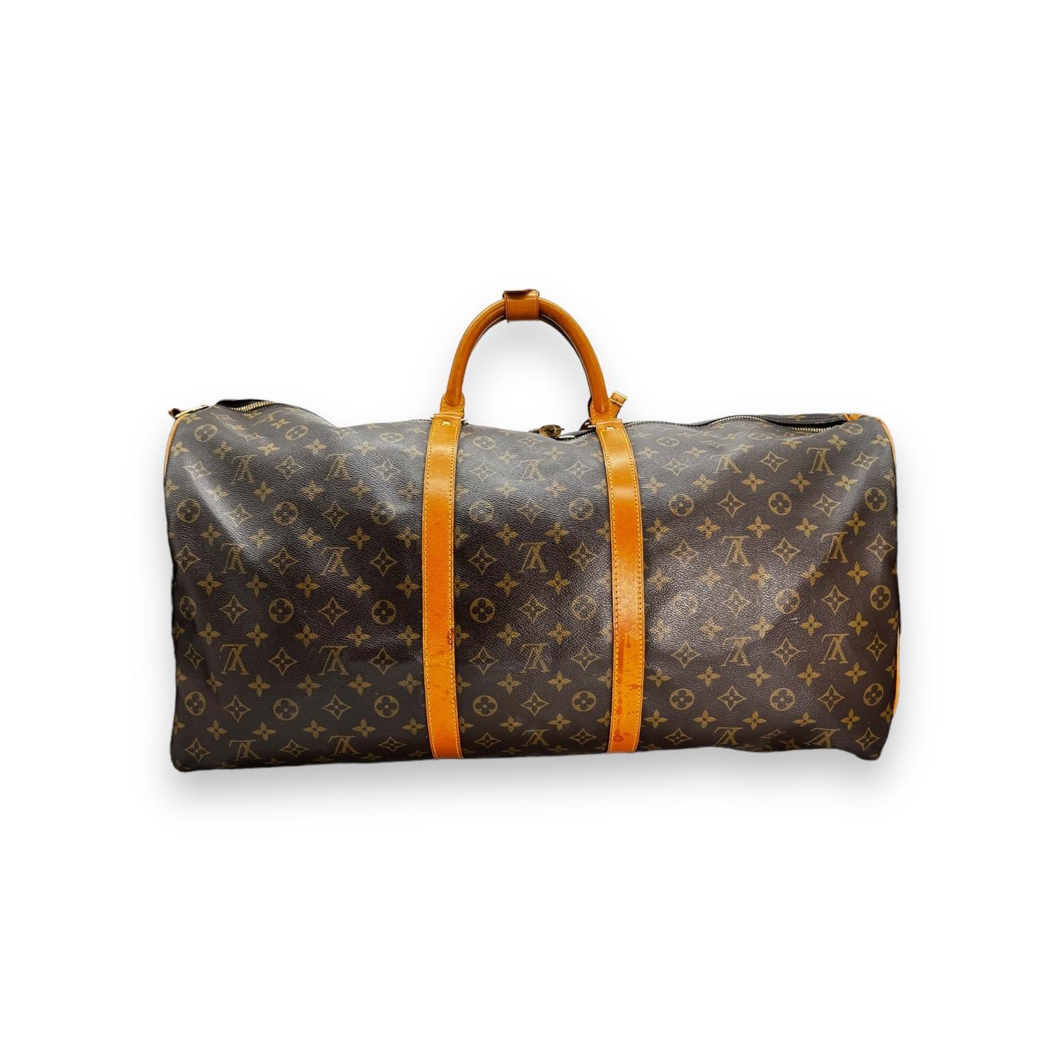 Elevate your travel with the Louis Vuitton Vintage Monogram Keepall Bandouliere 60. Crafted from coated canvas with a zip closure and brass hardware, it offers both style and security. Includes a strap, luggage tag, lock & key, and Entrupy COA. Very