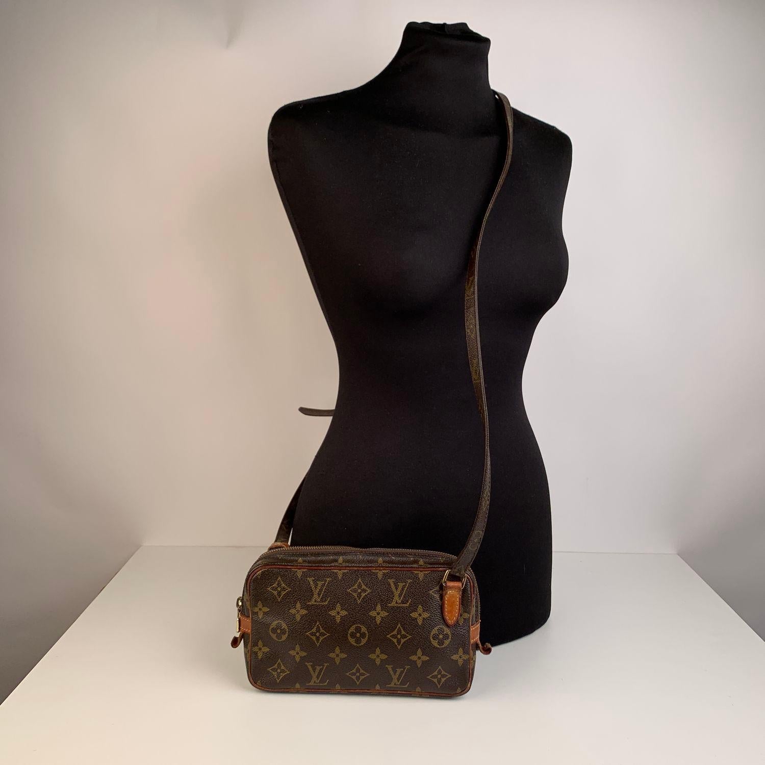 LOUIS VUITTON 'Marly Bandouliere'  crafted in timeless monogram canvas with vacchetta leather trim. Upper zipper closure. Golden brass hardware and adjustable canvas shoulder strap. Brown cross-grain leather lining.  'LOUIS VUITTON Paris - made in