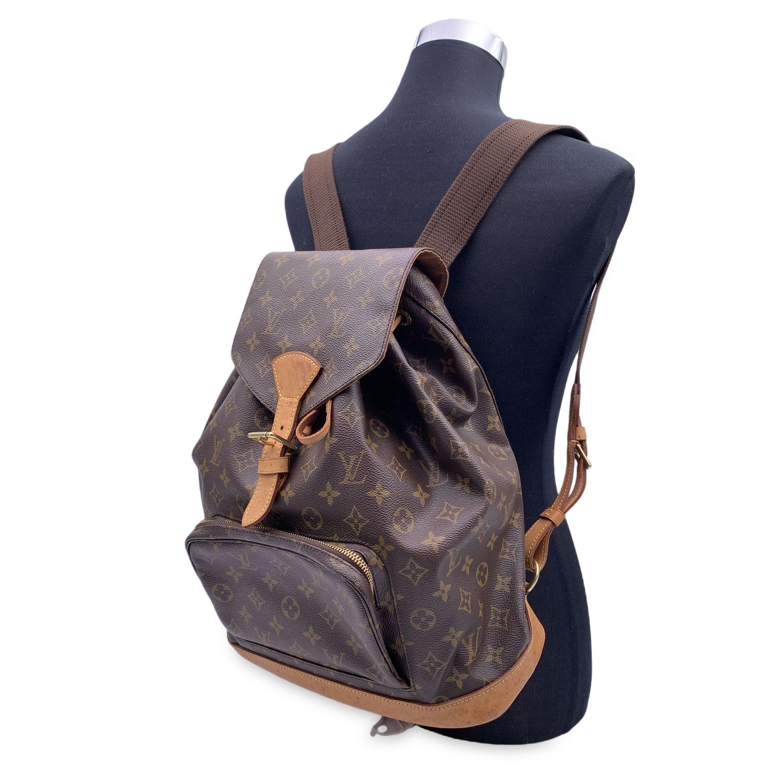 Casual yet sophisticated at the same time Louis Vuitton 'Montsouris GM' Backpack bag . Top is closed with flap with buckle closure and drawstring. 1 front zip pocket.Long and adjustable shoulder straps with gold metal hardware. Brown canvas