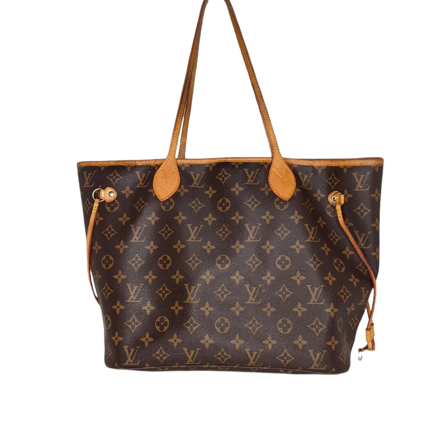 This stylish tote is crafted of classic Louis Vuitton monogram coated canvas. It features vachetta cowhide leather trim, handles, and side cinch cords with polished brass hardware. The top is open to a beige striped fabric interior, with a hanging