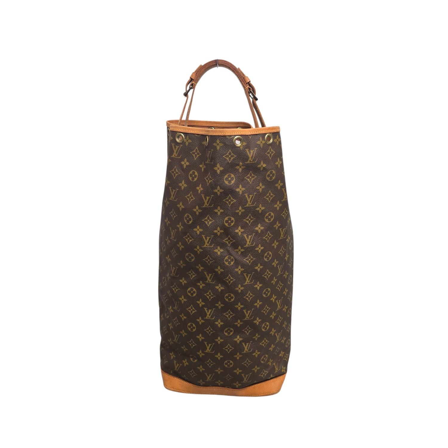 This Louis Vuitton Vintage Monogram Sac Marin is crafted of traditional Louis Vuitton monogram on toile canvas. The bag features vachetta cowhide leather side handle and trim and polished brass hardware. The top opens to an expansive cocoa fabric