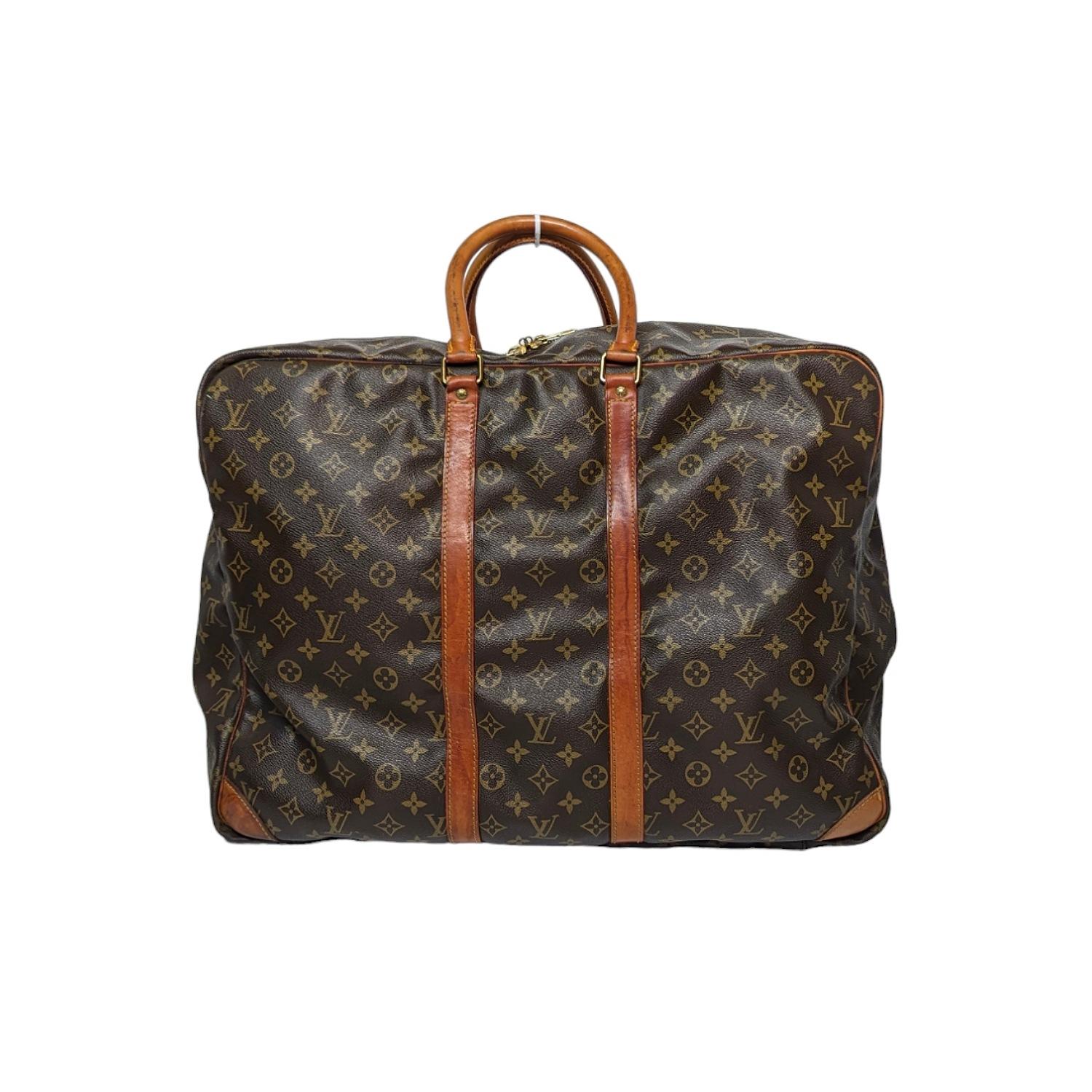 This Louis Vuitton Monogram Canvas single compartment soft suitcase is a member of the Sirius family and will fit in the overhead cabin. This soft suitcase is constructed out of Louis Vuitton's trademark, super-durable Monogram Canvas with cowhide