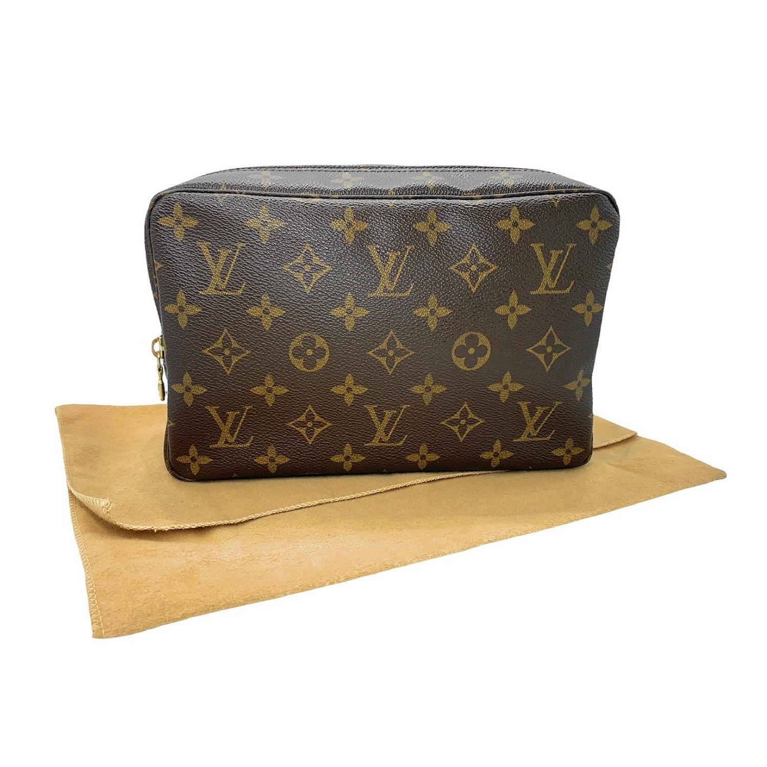 LV Louis Vuitton Toilette vintage pouch. Monogram canvas. Vachetta leather trims. Gold-tone hardware. Top zip closure. Interior textile lining in a neutral color. One interior flat pocket. Three elastic brush holders at the interior wall.