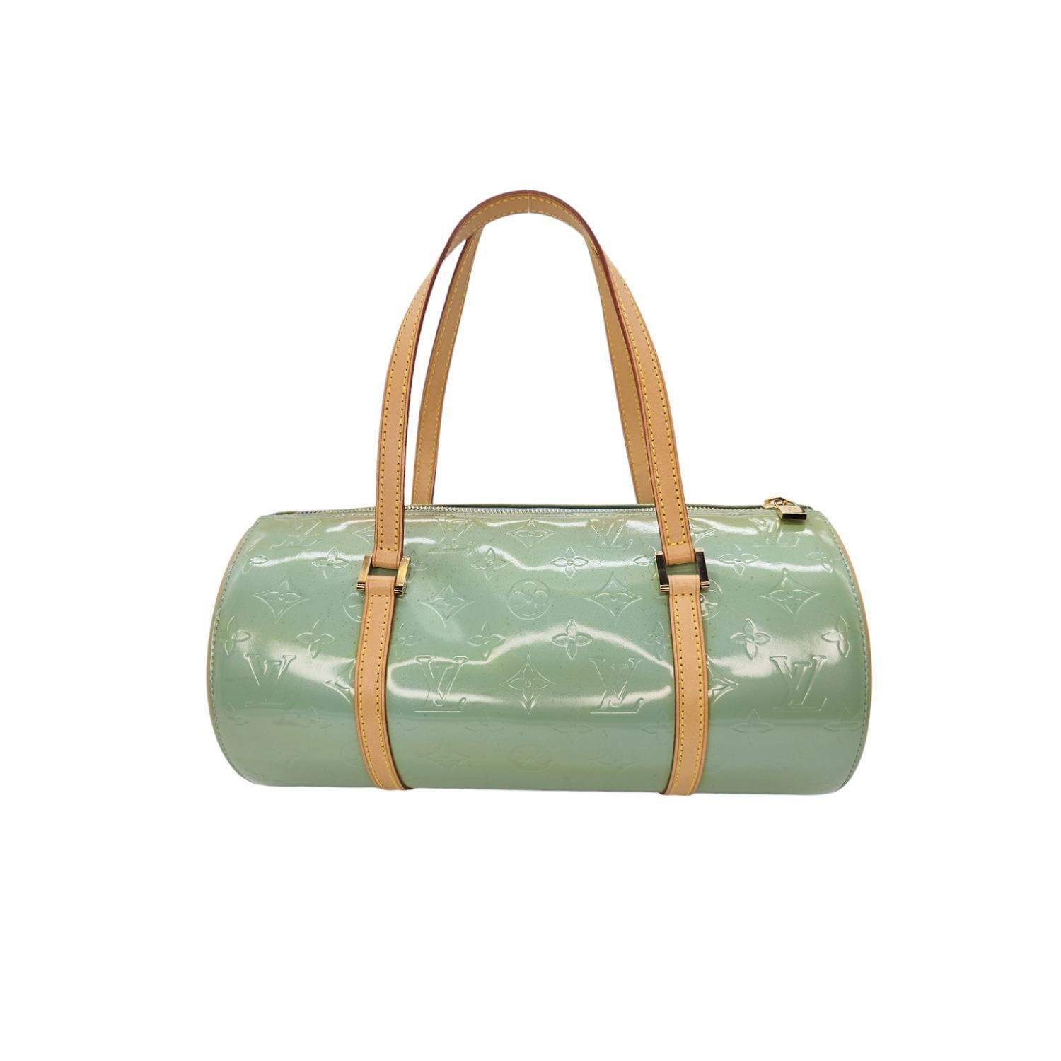 The Louis Vuitton Vintage Monogram Vernis Bedford Handbag is crafted with the signature LV monogram embossed on smooth patent leather. The eye-catching mint green patent exterior, spacious baby blue interior and side slip pocket make it both stylish