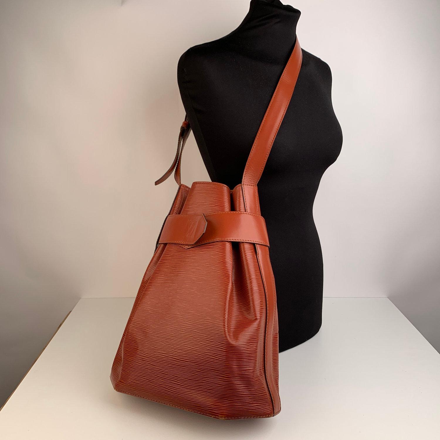 Sophisticated 'Sac d'epaule' Shoulder Bag by LOUIS VUITTON, crafted in tan Epi leather. This model is discontinued so it is no longer available in stores. The bag features a large main compartment and an adjustable leather shoulder strap. Microfiber
