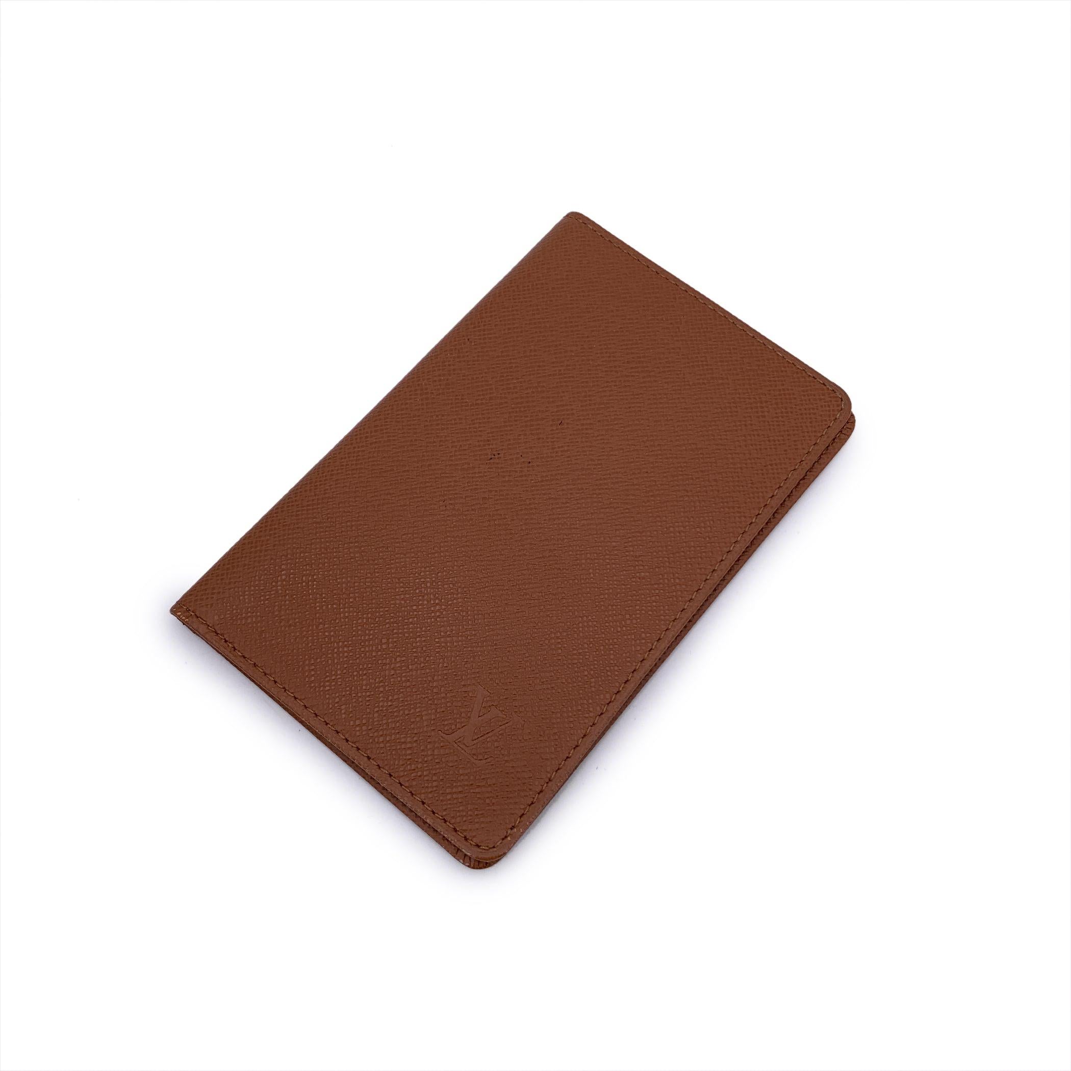 Step into the world of luxury with the Vintage Louis Vuitton Tan Taiga Leather Bifold ID Document holder Photo Holder Wallet. Crafted in France, this timeless wallet is made from Louis Vuitton's signature Taiga leather, offering both elegance and