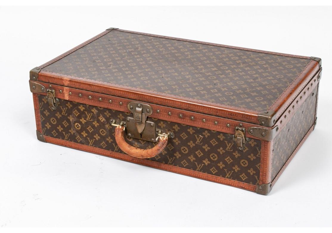 Classic travel luggage from 1930-1939.
Louis Vuitton suitcase with lovely leather trim and brass hardware.
The leather handle has repairs that do not detract from the look or function. Otherwise expected and slight age/use wear and lacking a key.