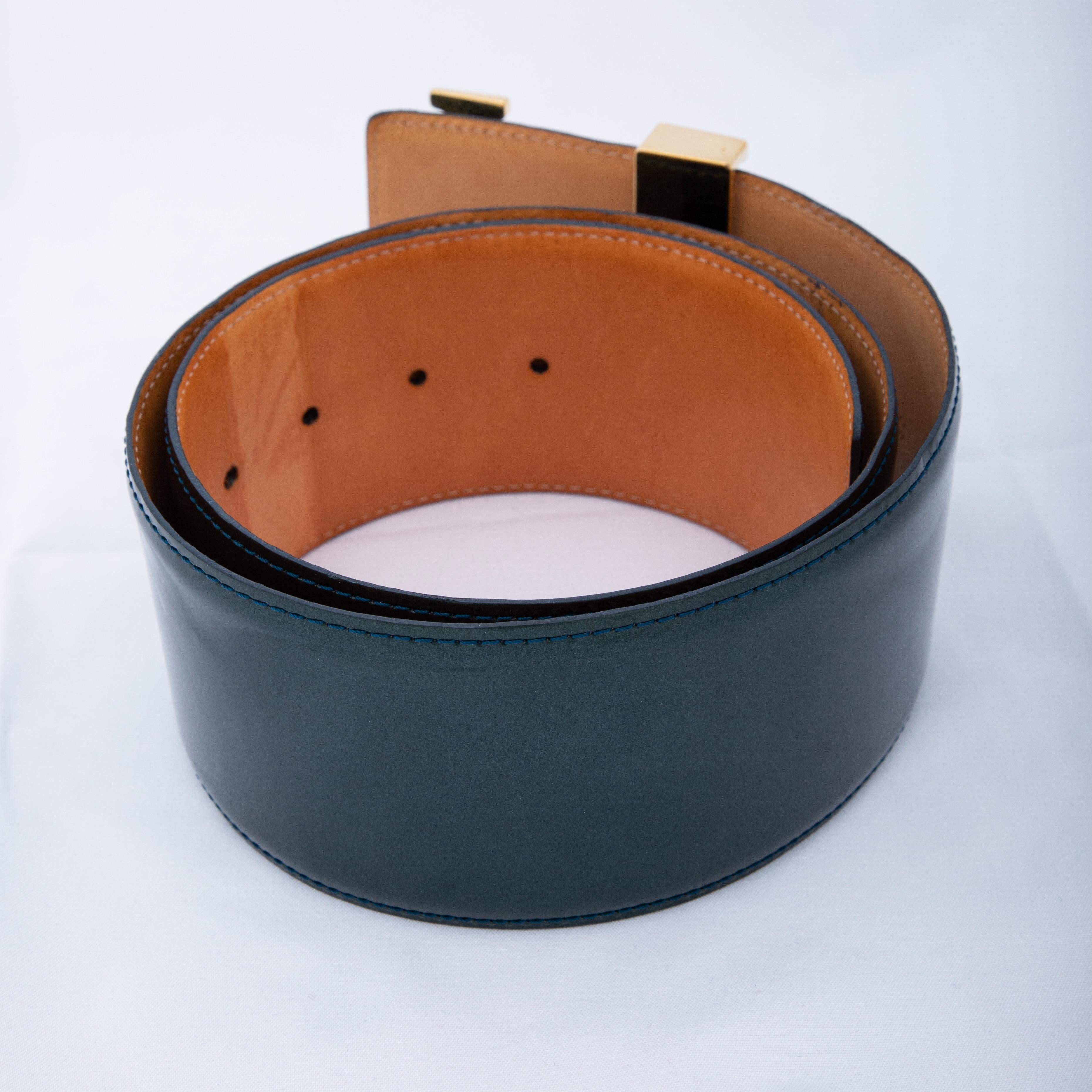 This belt is made of Louis Vuitton Vernis patent leather in dark green. The belt features a large logo buckle in gold tone and a vachetta leather back. The belt is from 2009.

COLOR: Dark green
MATERIAL: Patent leather
DATE CODE: CT2029
CODE: