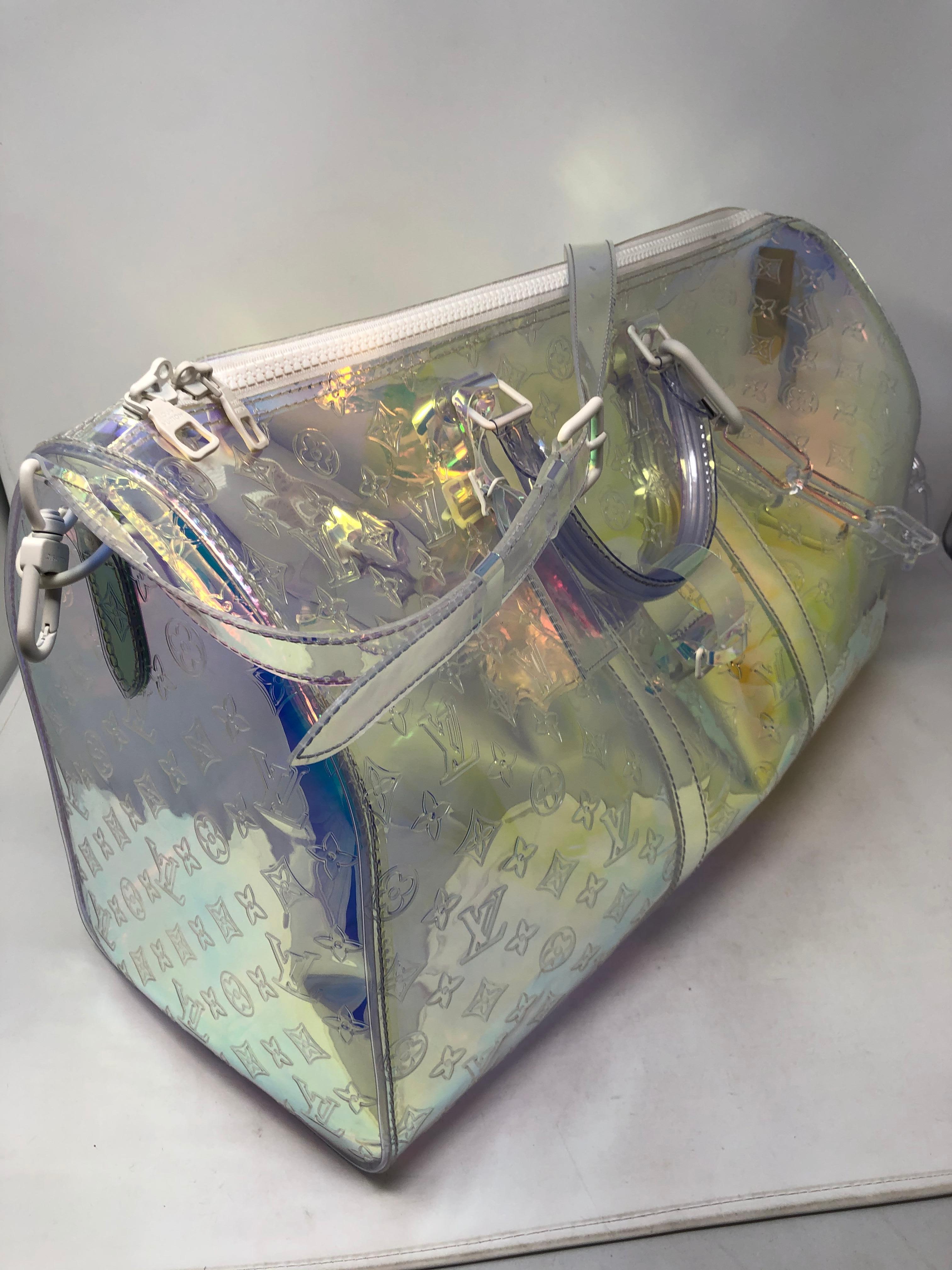 Louis Vuitton Prism Keepall by Virgil Abloh. 50 Keepall Bandouliere with matching strap. Clear and iridescent prism embossed PVC luggage designed by Virgil Abloh. From his first collection at Louis Vuitton. This is a unicorn of designer bags. Brand