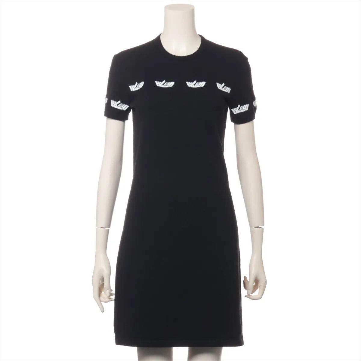 L'abito T-shirt in lana Louis Vuitton Vitesse in bianco e nero unisce un'estetica sportiva a una raffinata maestria artigianale. Realizzato in lana morbida e traspirante, l'abito presenta una silhouette rilassata a T-shirt che offre comfort e stile