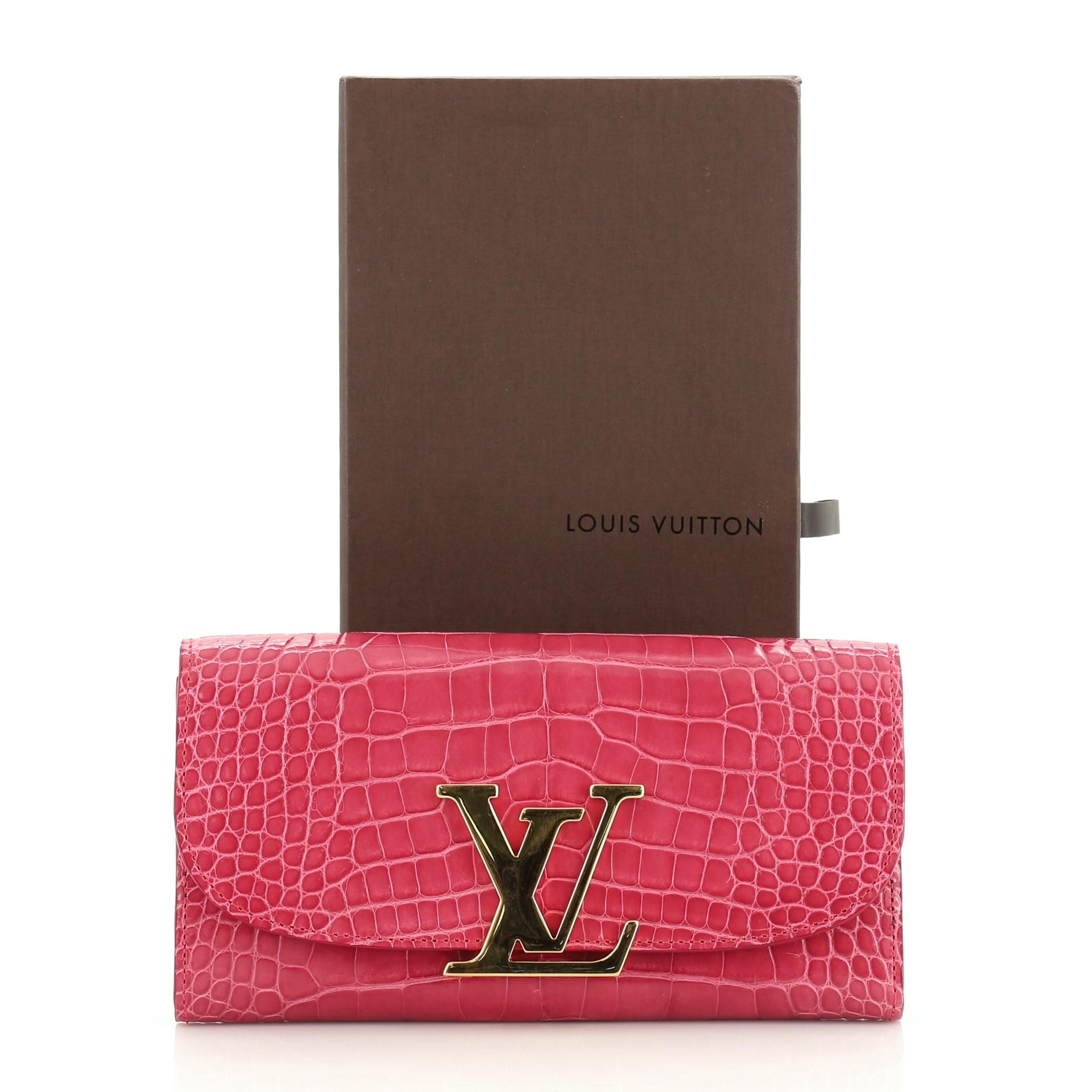 This Louis Vuitton Vivienne LV Wallet Alligator Long, crafted from genuine pink alligator, features an oversized LV logo snap closure and gold-tone hardware. Its flap opens to a pink leather interior with multiple card slots, slip pocket and zip