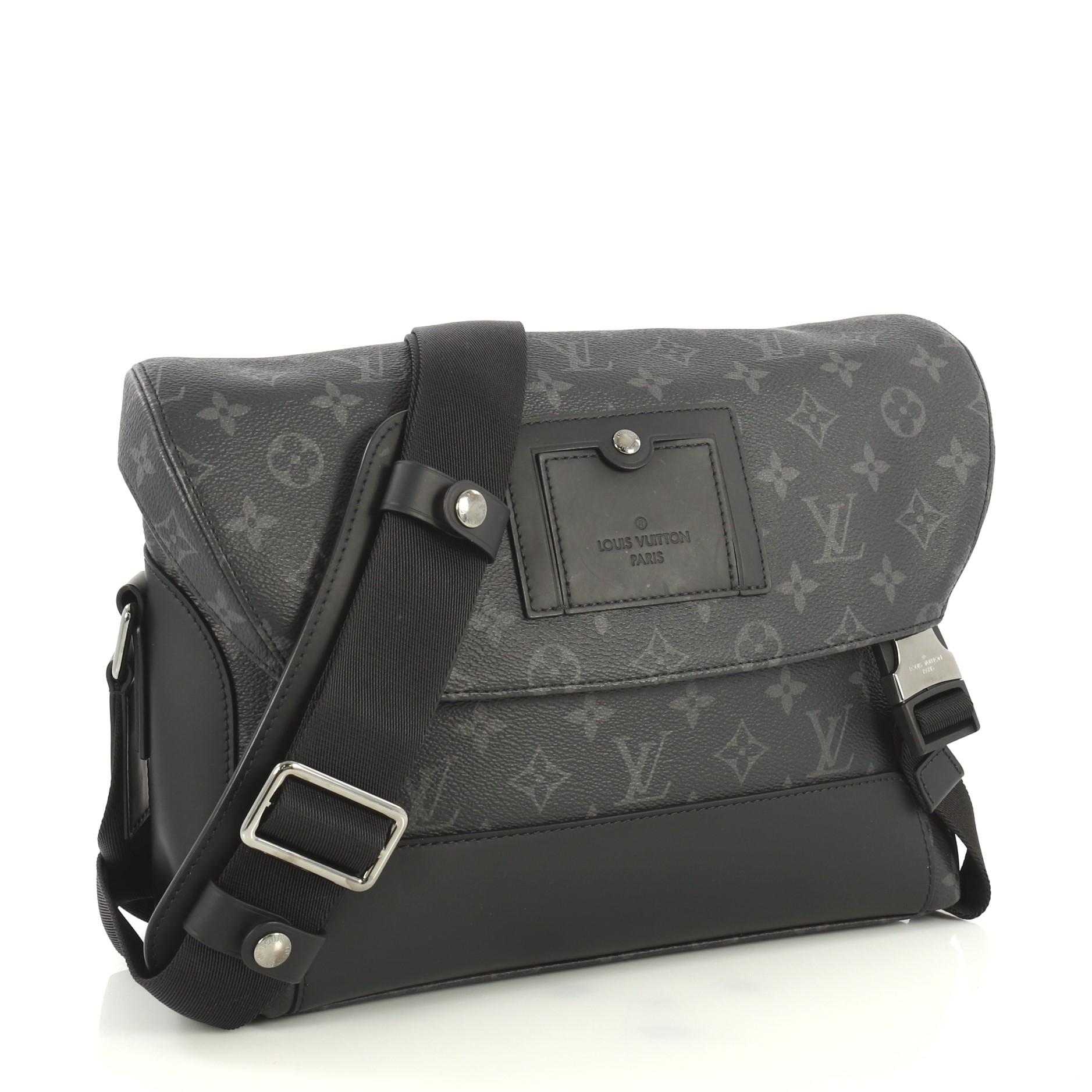 This Louis Vuitton Voyager Messenger Bag Monogram Eclipse Canvas PM, crafted from black monogram eclipse coated canvas, features an adjustable strap and silver-tone hardware. Its flap with buckle closures open to a black fabric interior with zip and