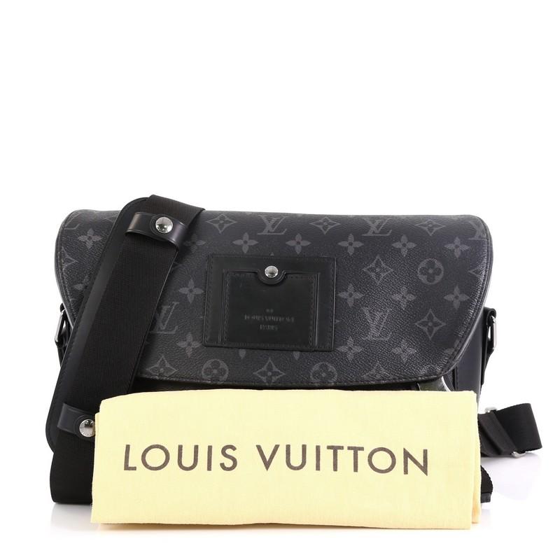 This Louis Vuitton Voyager Messenger Bag Monogram Eclipse Canvas PM, crafted from black monogram eclipse coated canvas, features an adjustable strap and silver-tone hardware. Its flap with buckle closures open to a black fabric interior with zip and