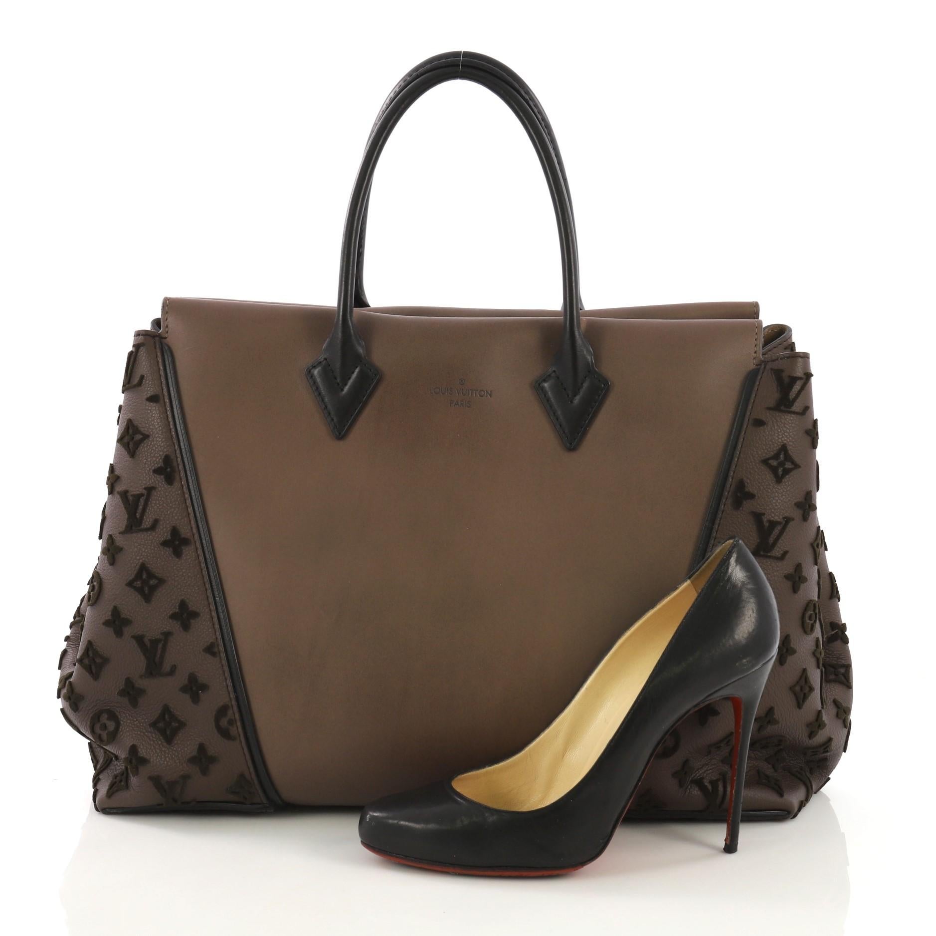 This Louis Vuitton W Tote Cuir Orfevre and Veau Cachemire GM, crafted brown cuir orfevre leather and veau cachemire leather, features dual rolled handles, expansive sides with tufted velvet monogram embossed patterns, protective base studs and