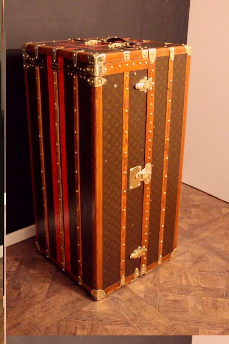 This impressive Louis Vuitton wardrobe features stenciled monogram canvas, lozine trims and solid brass locks.Its top lifts up.
Locks and studs are all marked Louis Vuitton. Customised painted red and black stribes all around as well as the name of