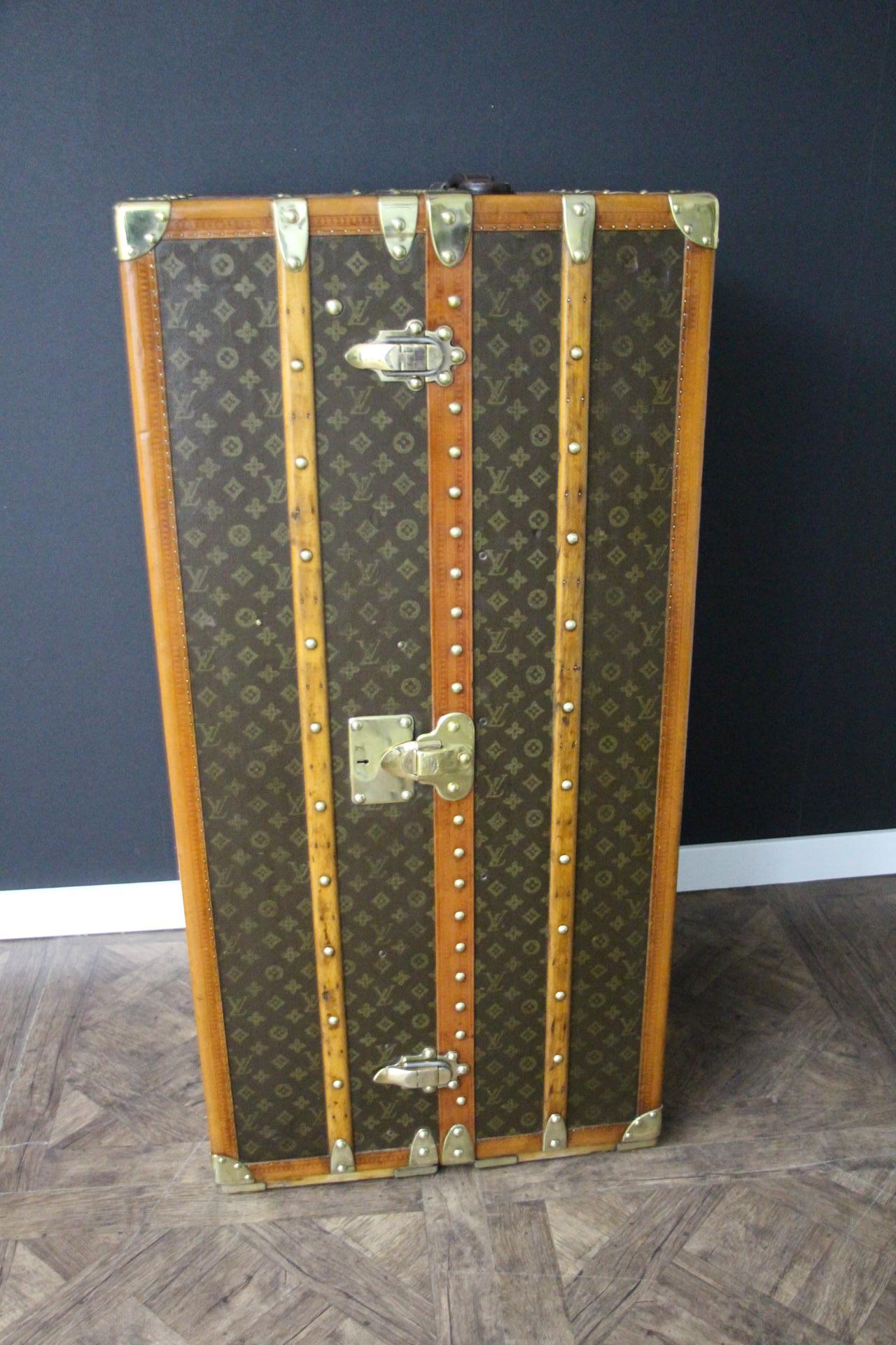 This superb Louis Vuitton wardrobe features stenciled monogram canvas, honey color lozine trims and solid brass lock, clasps and studs.
Lock, clasps and studs are all marked Louis Vuitton. Customised hand painted blue and orange flag on its top and