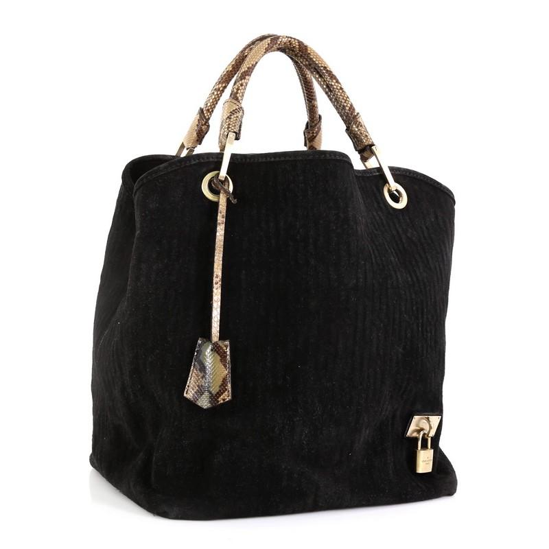 This Louis Vuitton Whisper Bag Monogram Suede and Python GM, crafted from black embossed monogram suede, features dual-rolled genuine python handles and matte gold-tone hardware. Its wide-open tops showcase a gray leather interior with a center zip