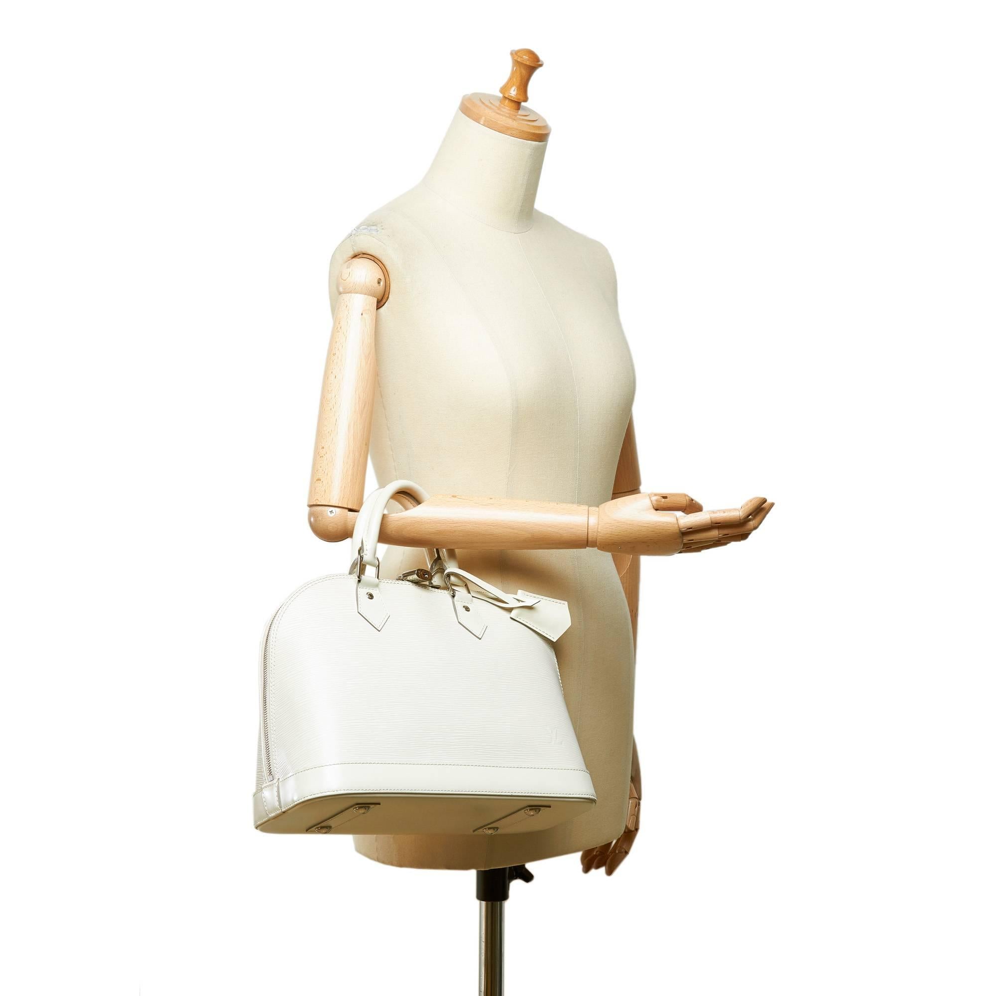 - Louis Vuitton white and ivory epi leather Alma Pm handbag. 

- Featuring rolled handles, a top zip closure, and an interior slip pocket. 

- Size: 32cm x 24cm x 15cm. Hand Drop: 9cm. 

- Included: Dust bag and original box. 

-  Condition: