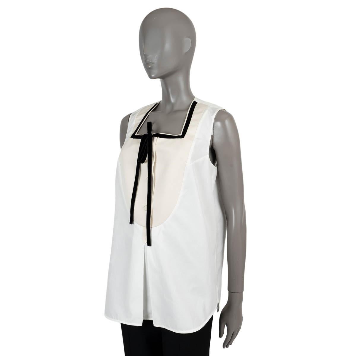 100% authentic Louis Vuitton sleeveless bip poplin blouse in white cotton (100%). The design features a cream grosgrain insert with buttons, with a black velvet trim and front box pleat. Unlined. Has been worn and is in excellent condition.