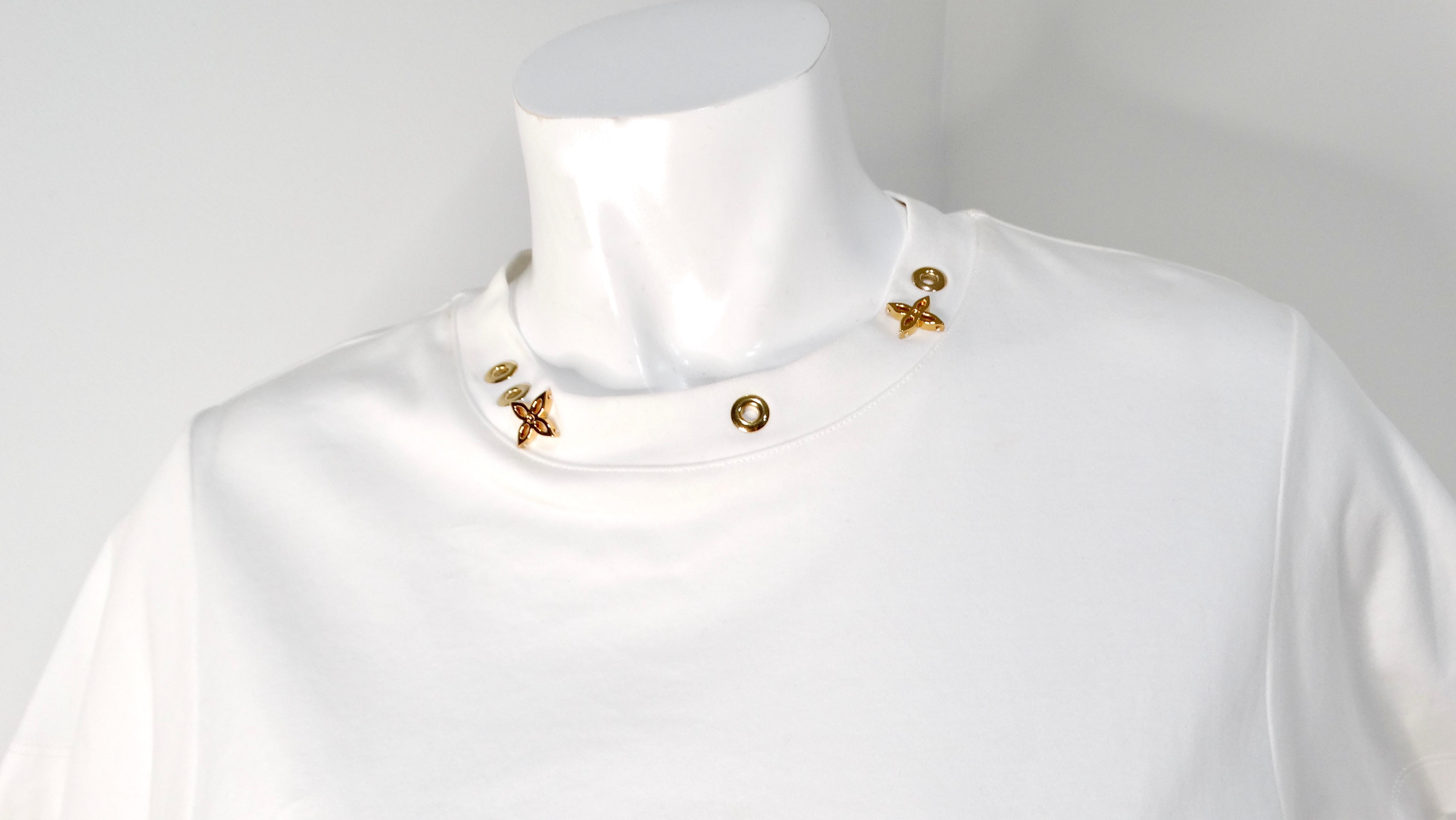 Elevate your casual wardrobe with the luxurious Louis Vuitton White Cotton T-shirt featuring striking gold-tone monogram charms. This classic white tee is far from ordinary, adorned with the iconic LV charms meticulously arranged around the collar,