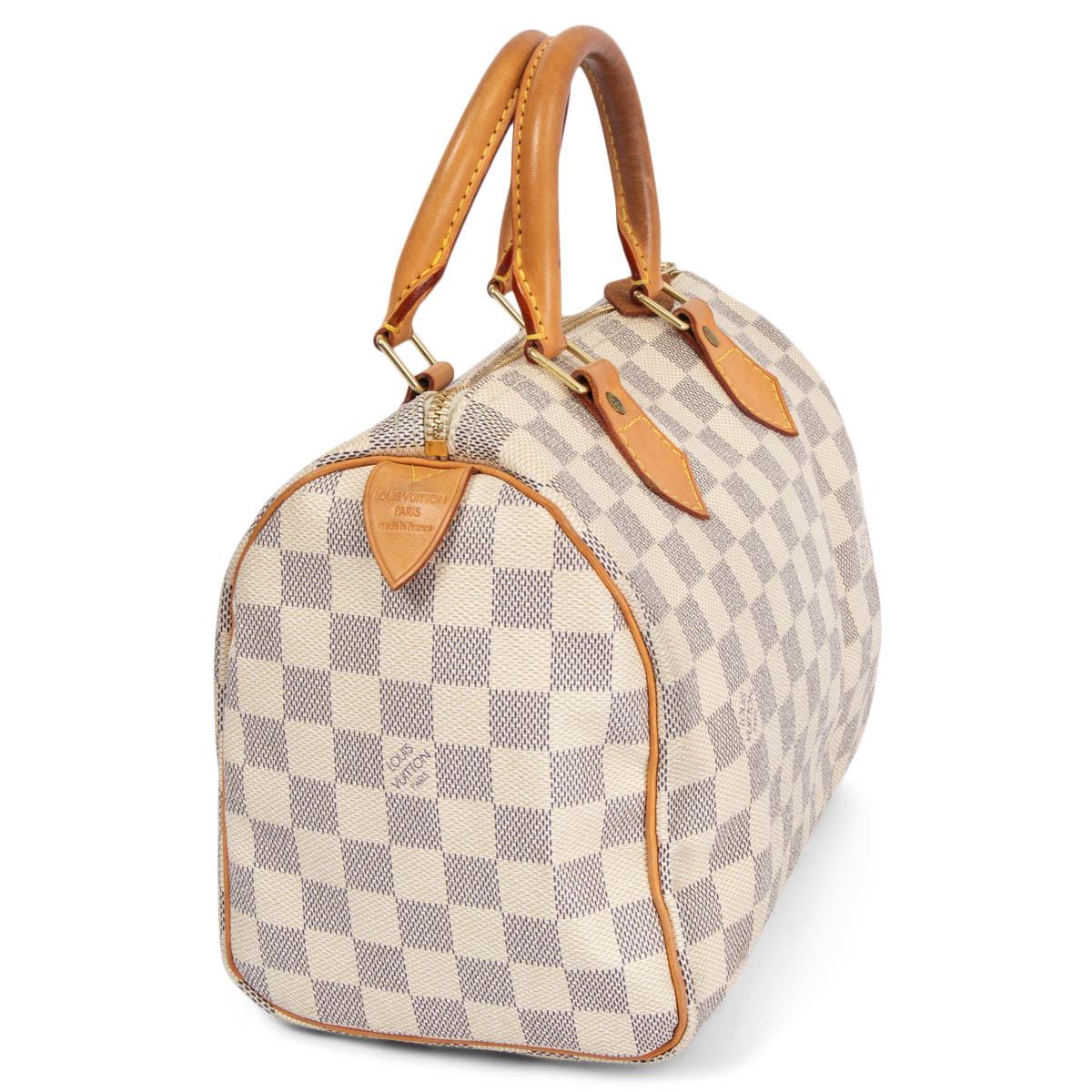 100% authentic Louis Vuitton Speedy 25 in off-white and navy Damier Azur canvas with details in natural leather. Closes with a zipper on top. Lined in canvas with an open pocket against the back. Has been carried with some darkening the handles.