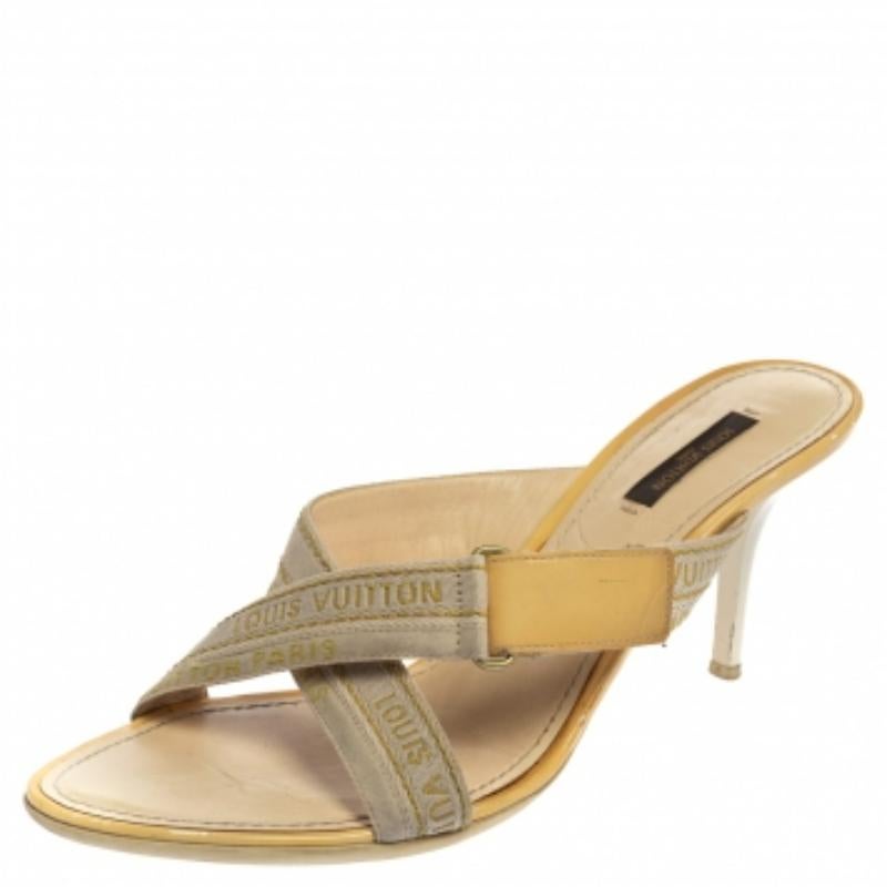 Designed with open toes and logo detailed cross vamp straps, these Louis Vuitton mule sandals are simply amazing! They've been beautifully crafted from canvas and leather and endowed with comfortable insoles. They are elevated on 8 cm heels.