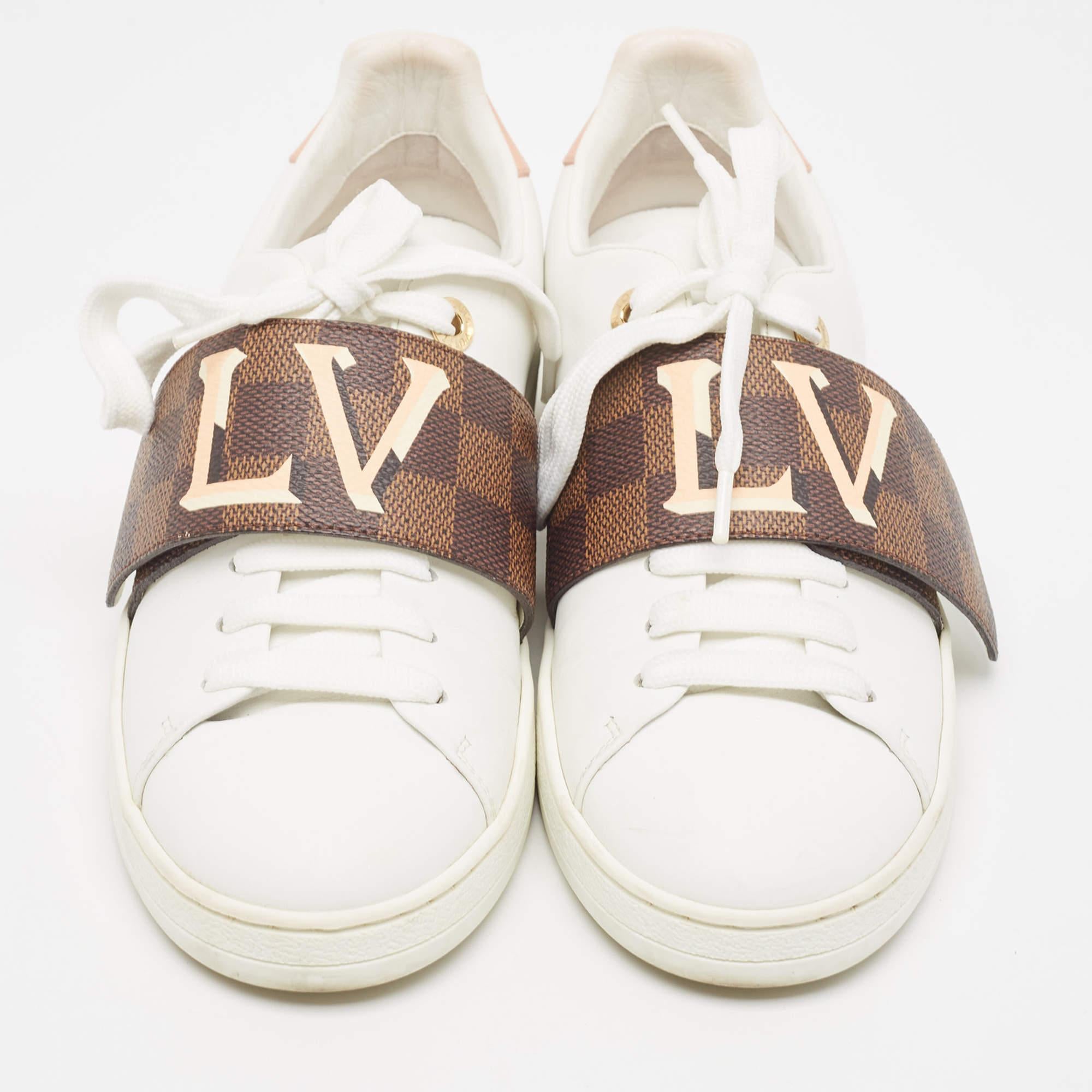 Pour rehausser votre look décontracté, ces baskets blanches Louis Vuitton sont dotées d'une bande velcro contrastante sur l'empeigne à lacets. Les étampes de la marque ajoutent une touche de luxe au design.

