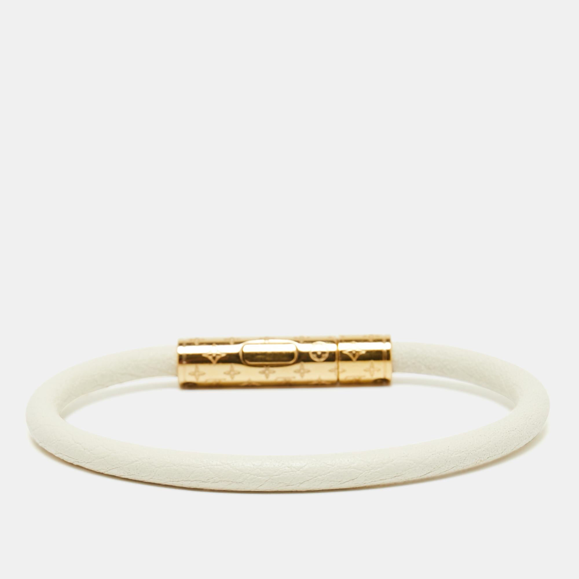 Let all eyes be on you when you step out wearing this fabulous Confidential bracelet from Louis Vuitton! The lovely white creation is crafted from leather and styled with a gold-tone metal fastener that is engraved with the signature