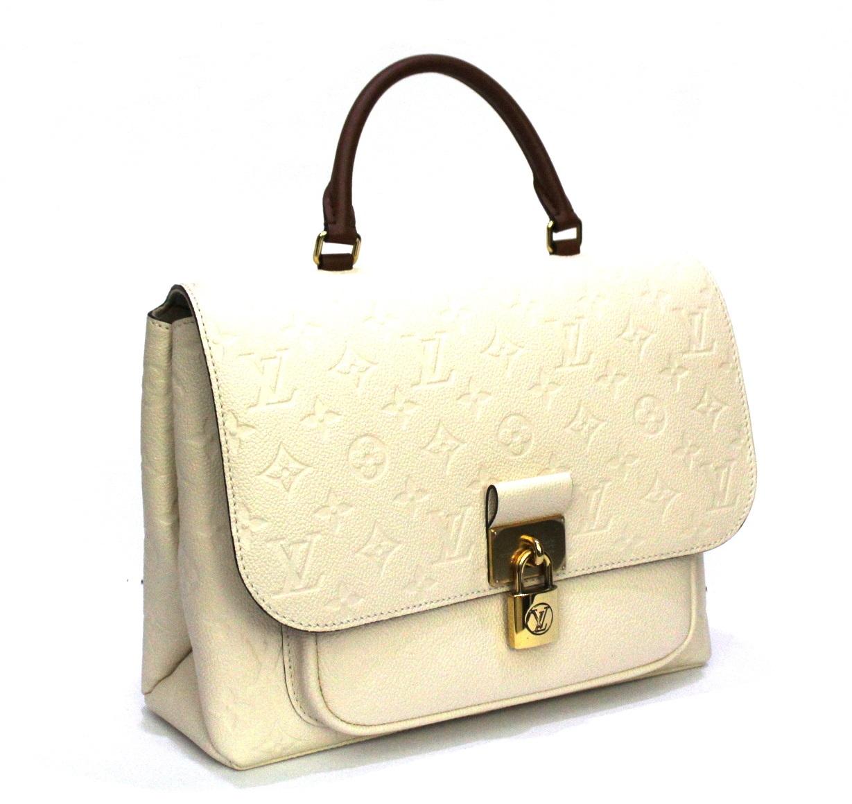 Louis Vuitton Tasche Marignan Empreinte Modell aus cremefarbenem Leder mit biskuitfarbenen Details und goldener Hardware. 
Magnetischer Knopfverschluss:: innen recht geräumig. Ausgestattet mit oberem Griff und abnehmbarem Schulterriemen. 
Diese