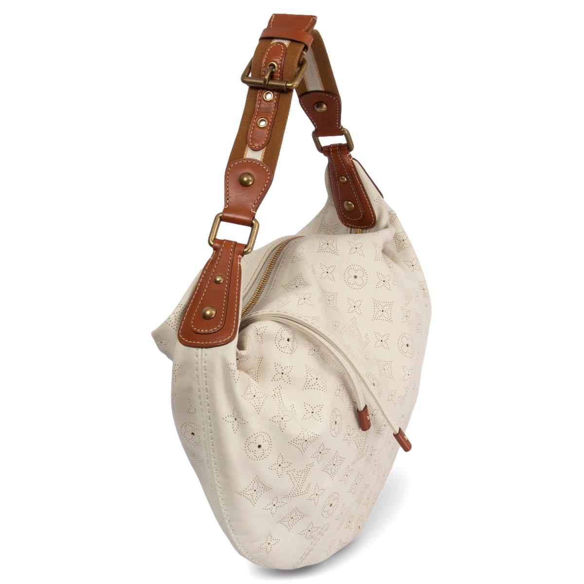 100% authentic Louis Vuitton Onatha GM Hobo in off-white Mahina leather with cognac leather trimming and off-white brown canvas shoulder strap. Opens with a tassel zipper on top and is lined in lilac and white flower print cotton with one open