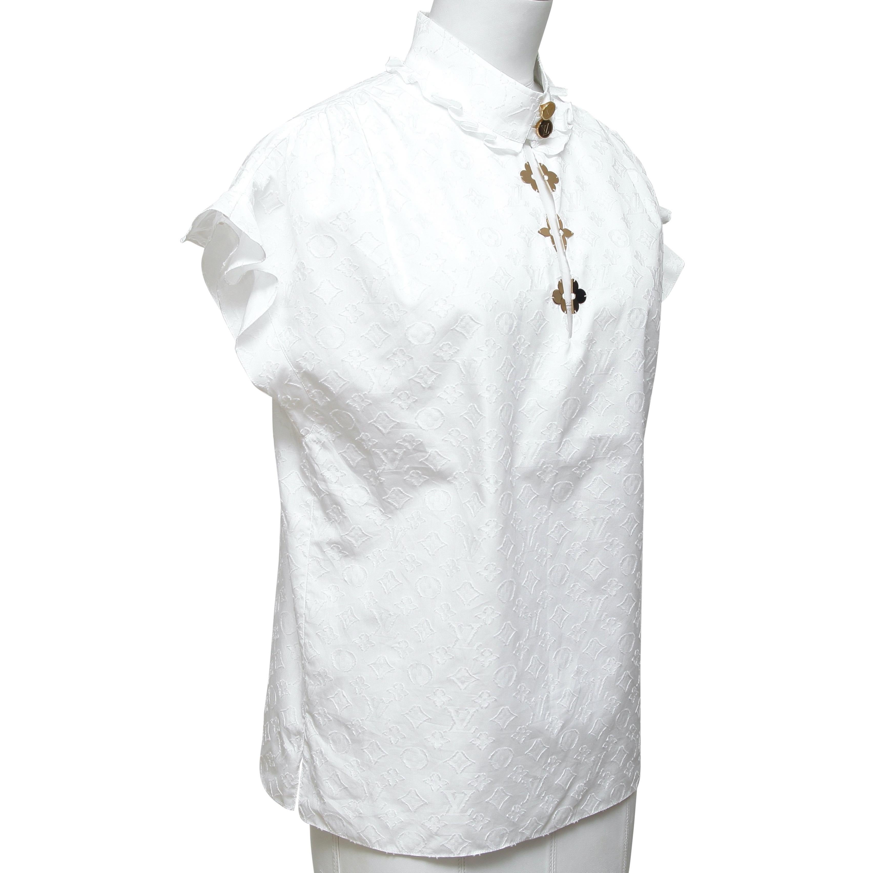 GUARANTEED AUTHENTIC LOUIS VUITTON WHITE MONOGRAM FRILL BLOUSE

Retail excluding sales taxes $1,320

Design:
- White monogram poplin cotton print.
- Stand up collar, two button closure.
- Floral monogram floral embellishments at front.
- Frill