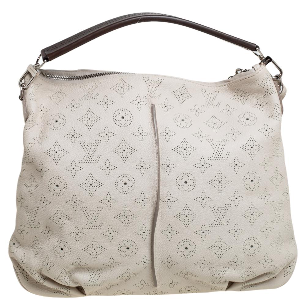 Crafted from Mahina leather, this white-hued Selene bag from Louis Vuitton features a monogram pattern all over. The bag comes with a top handle, a padlock, and a key clochette. The zip-top closure opens to an Alcantara-lined interior that houses a