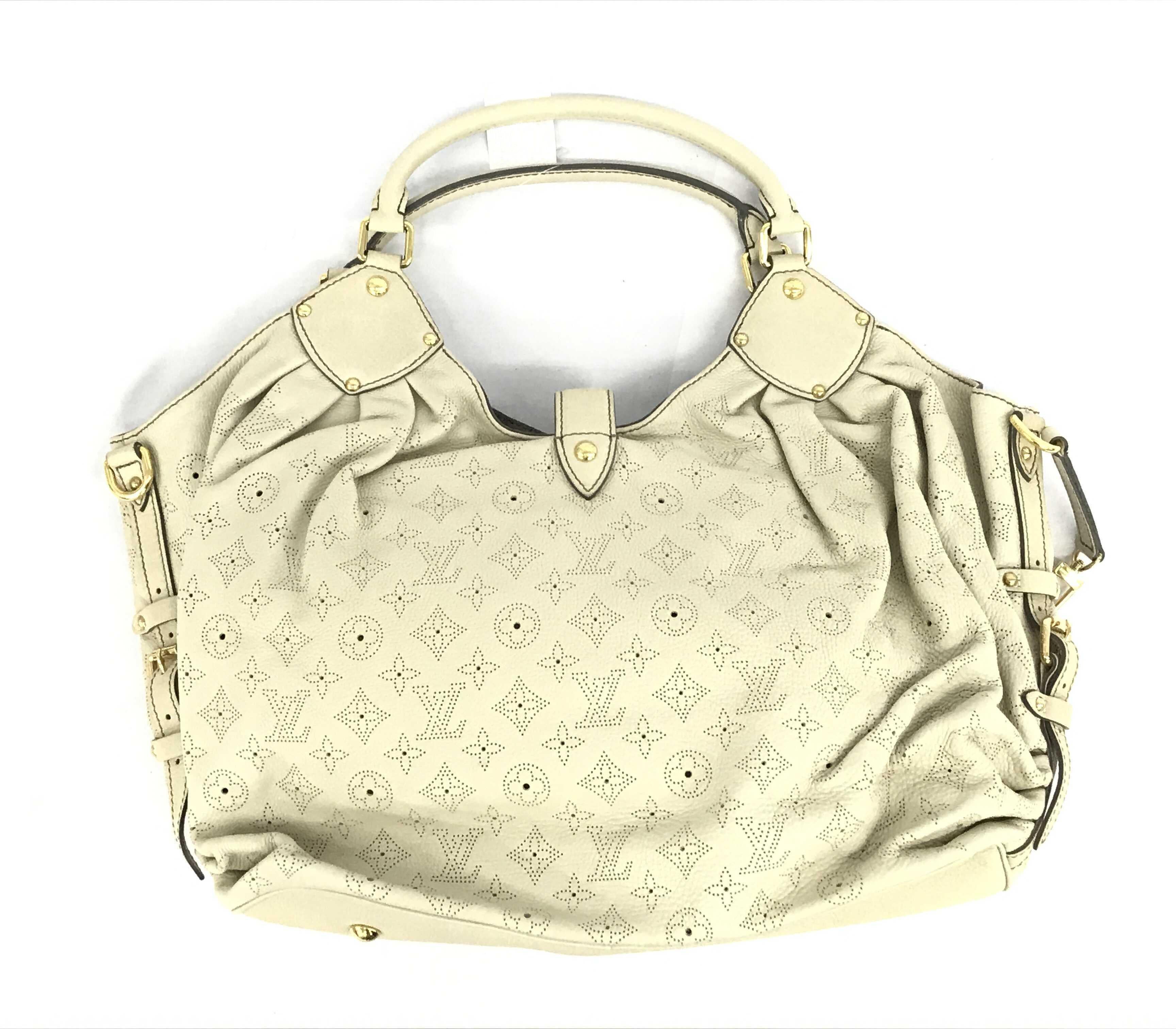 White perforated monogram Mahina leather Louis Vuitton XL hobo bog with calfskin leather, gray Alcantara interior lining, one zip pocket, double rolled leather handles, open top with leather flap tab and push-lock closure, gold-tone
