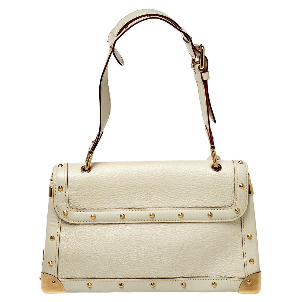 Crafted in a pristine white color, this Louis Vuitton bag is one-of-a-kind. With a gold-tone studded exterior, it will add luxe and chic appeal to your outfit. The gold-tone hardware on the trim and corners adds a little edge and shine to the look.